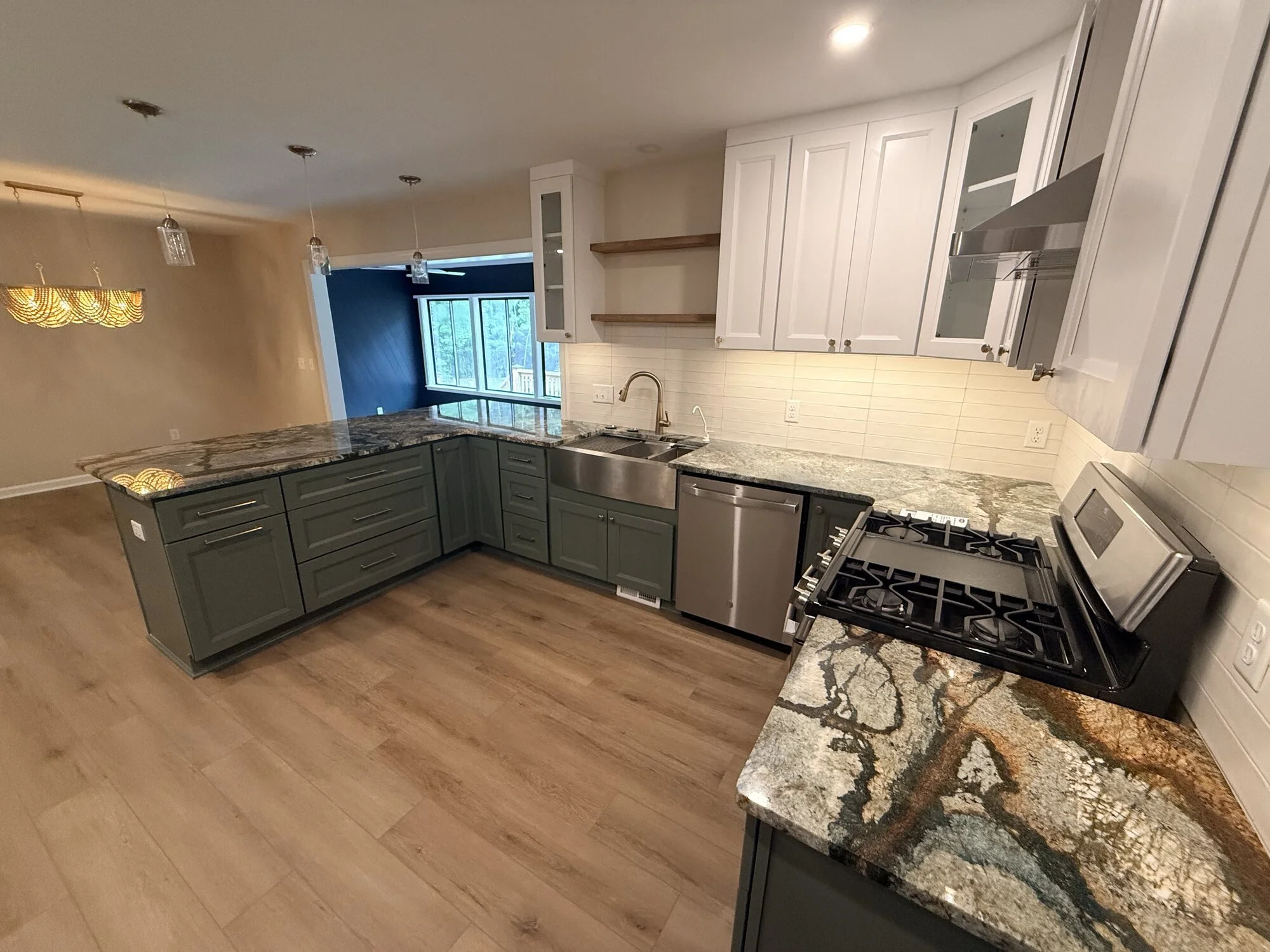 After — wide view of the finished kitchen with two-tone cabinetry and granite island