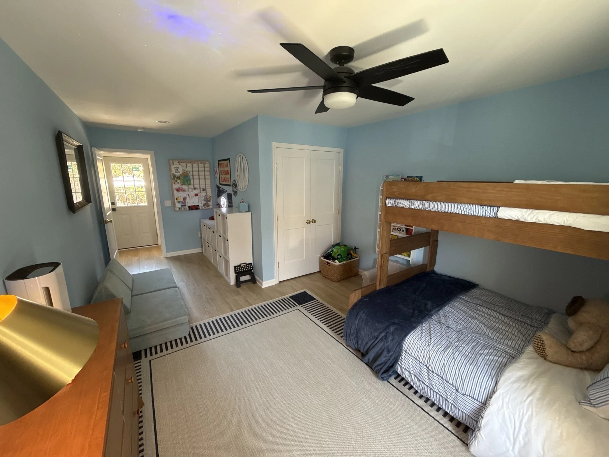 After — finished bedroom with ceiling fan, fresh paint, and new flooring