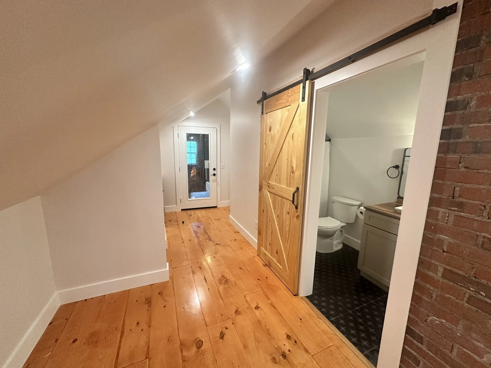 After - barn door detail against the rustic wood floors