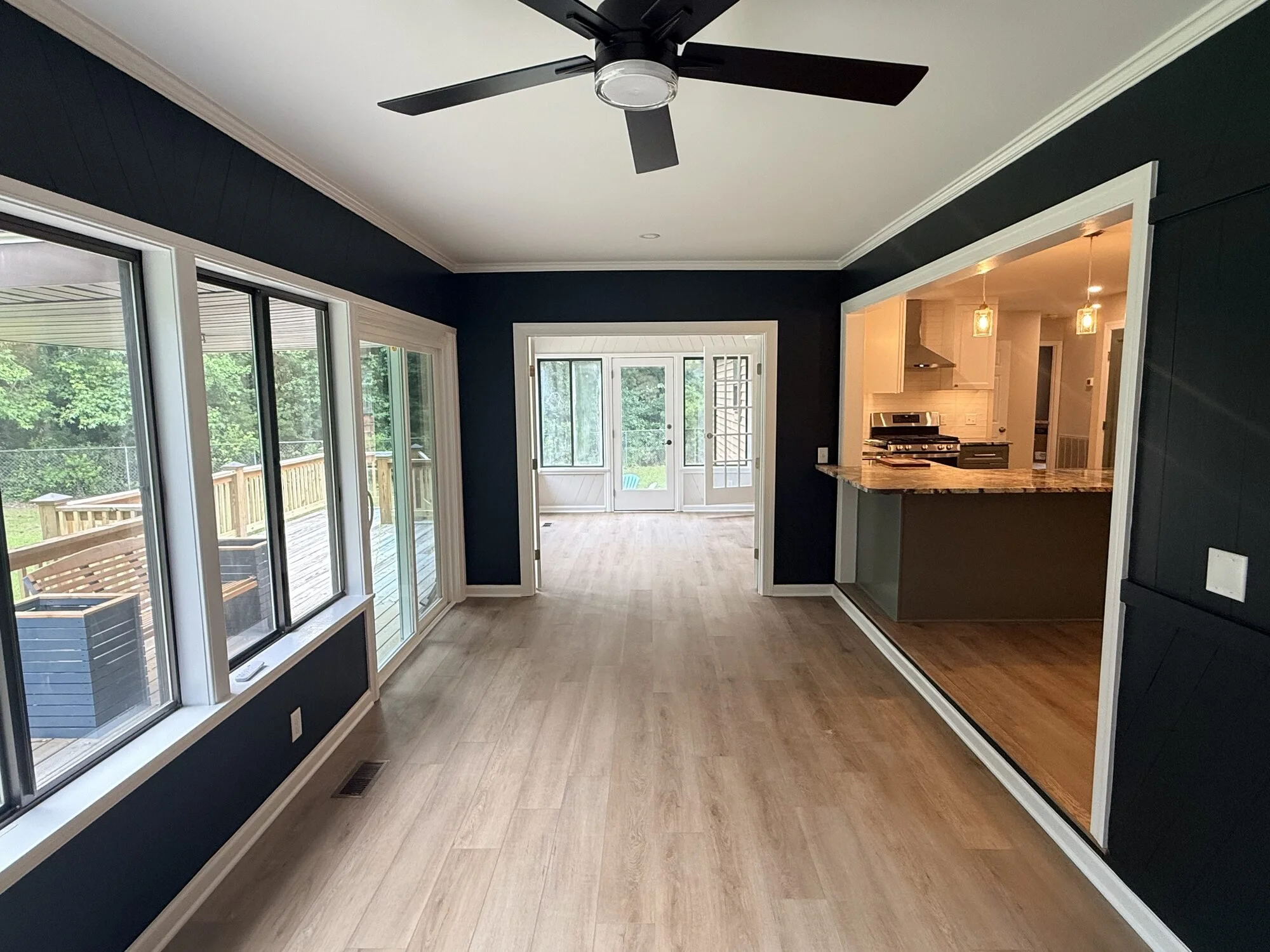 After — the sunroom now bright and connected to the kitchen with wall color, exterior sliding door and floors