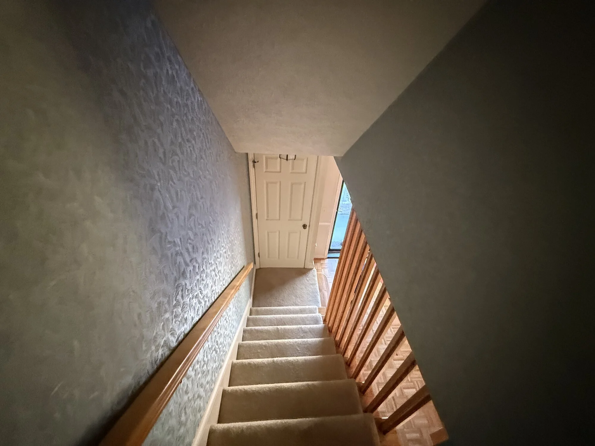 Before— dark, closed-in stairwell with original wood balusters and railing