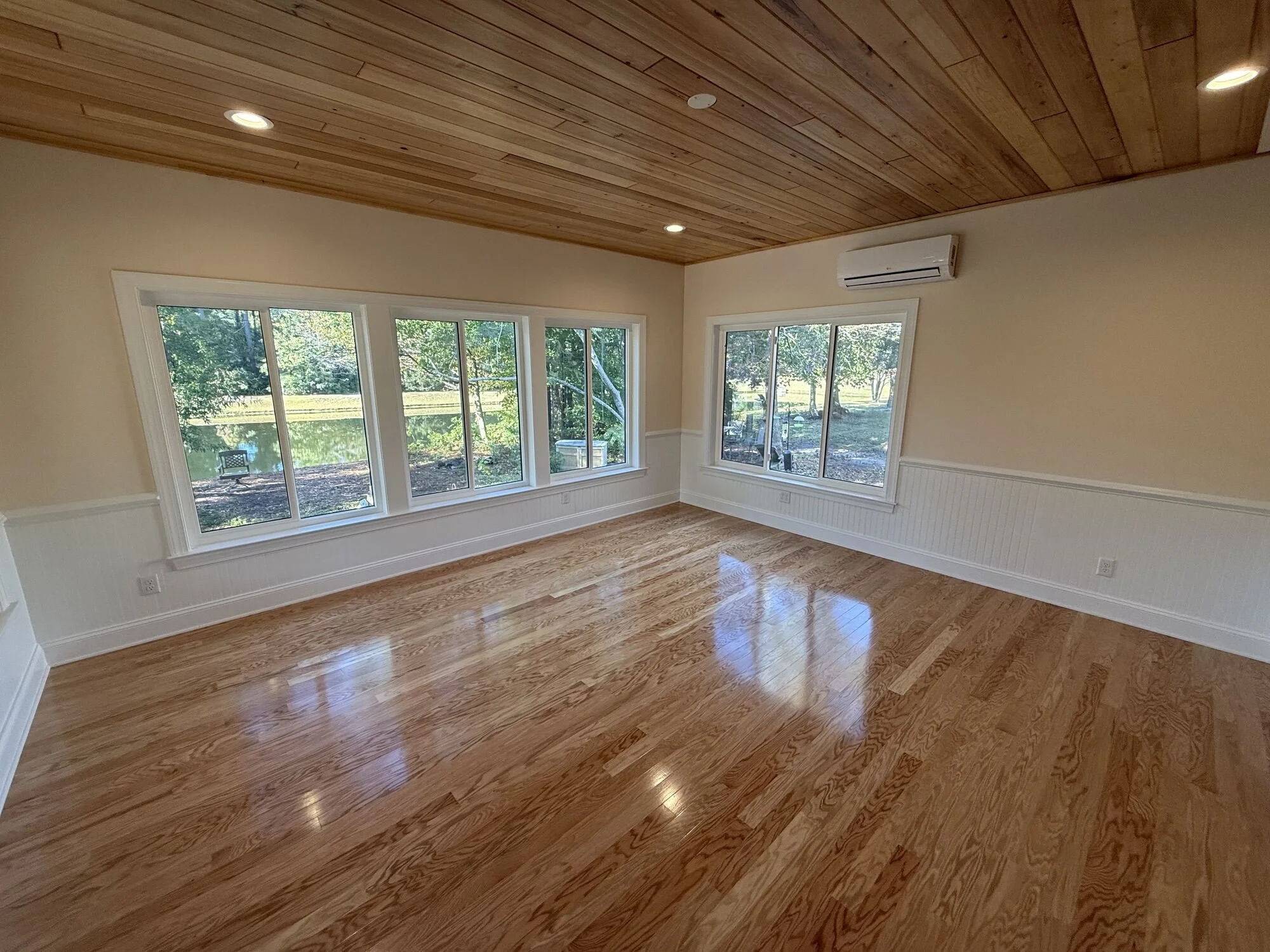 After — window walls and beadboard wainscoting flooding the room with light