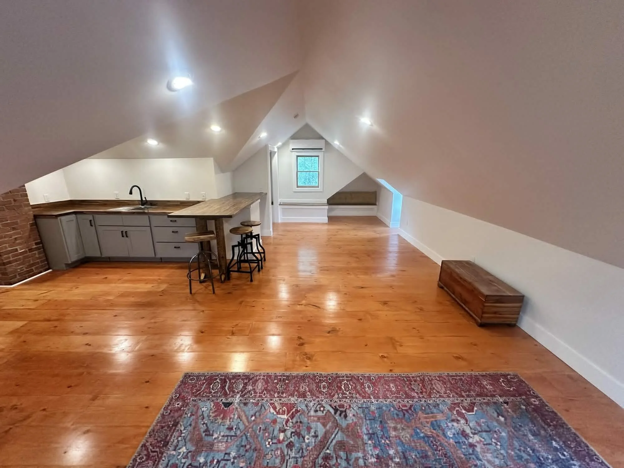 After — kitchenette with bar seating and new window trim under the eave
