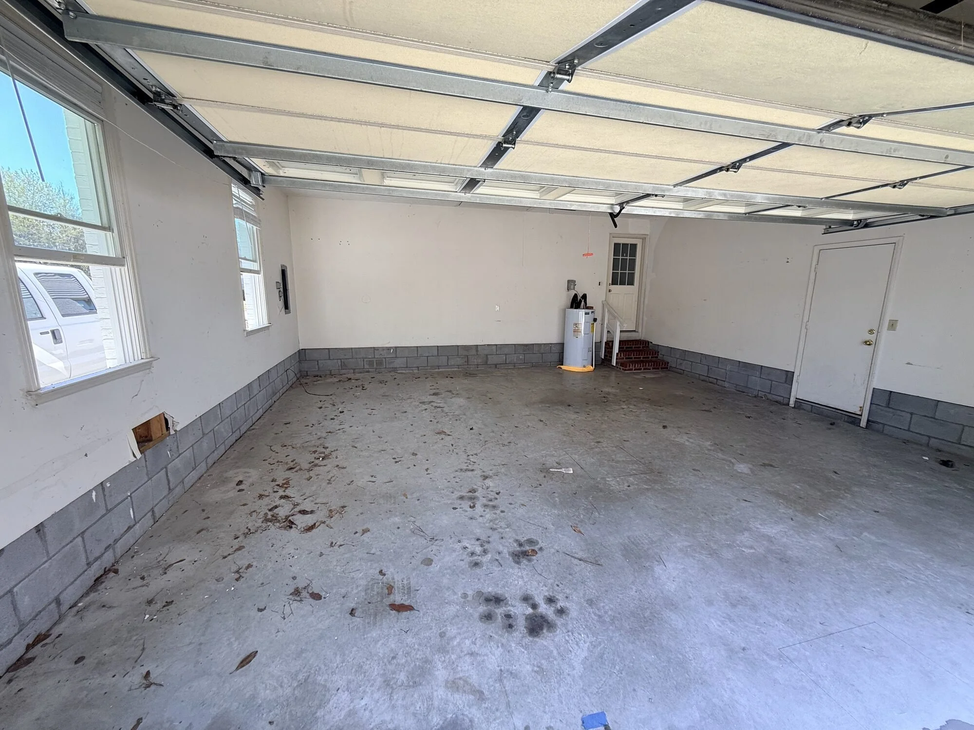 Before — empty two-car garage with bare concrete floor
