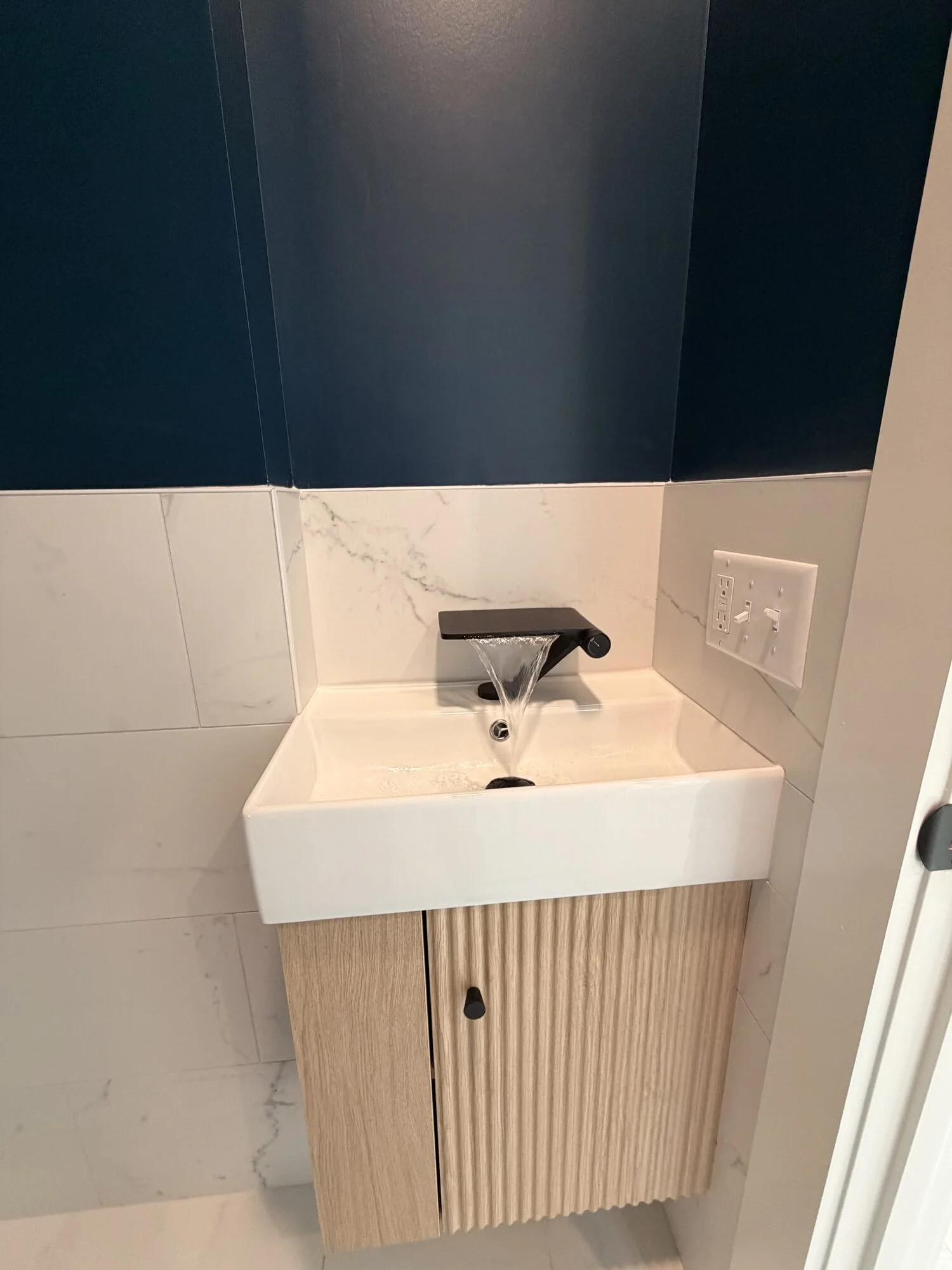 After — vanity and matte black fixture detail in the new bath