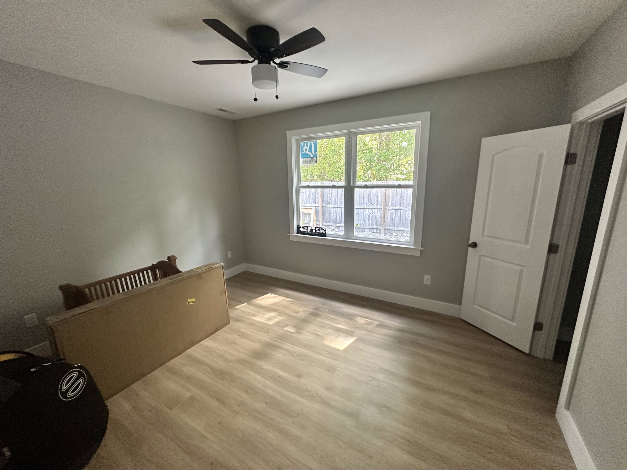 After — finished bedroom with ceiling fan, closet, and new flooring