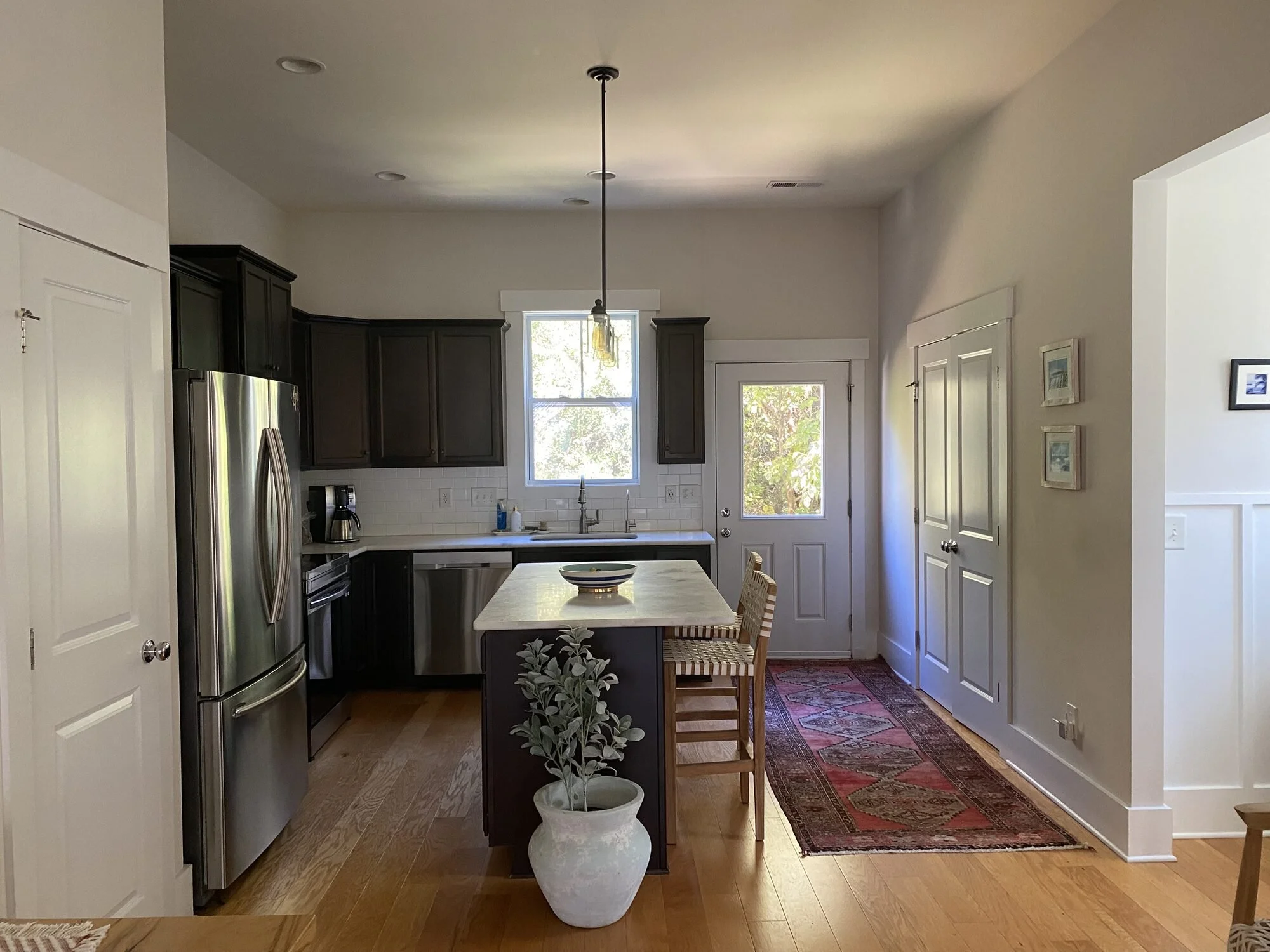 Before — the kitchen and island with bar seating just off the old exterior door and deck
