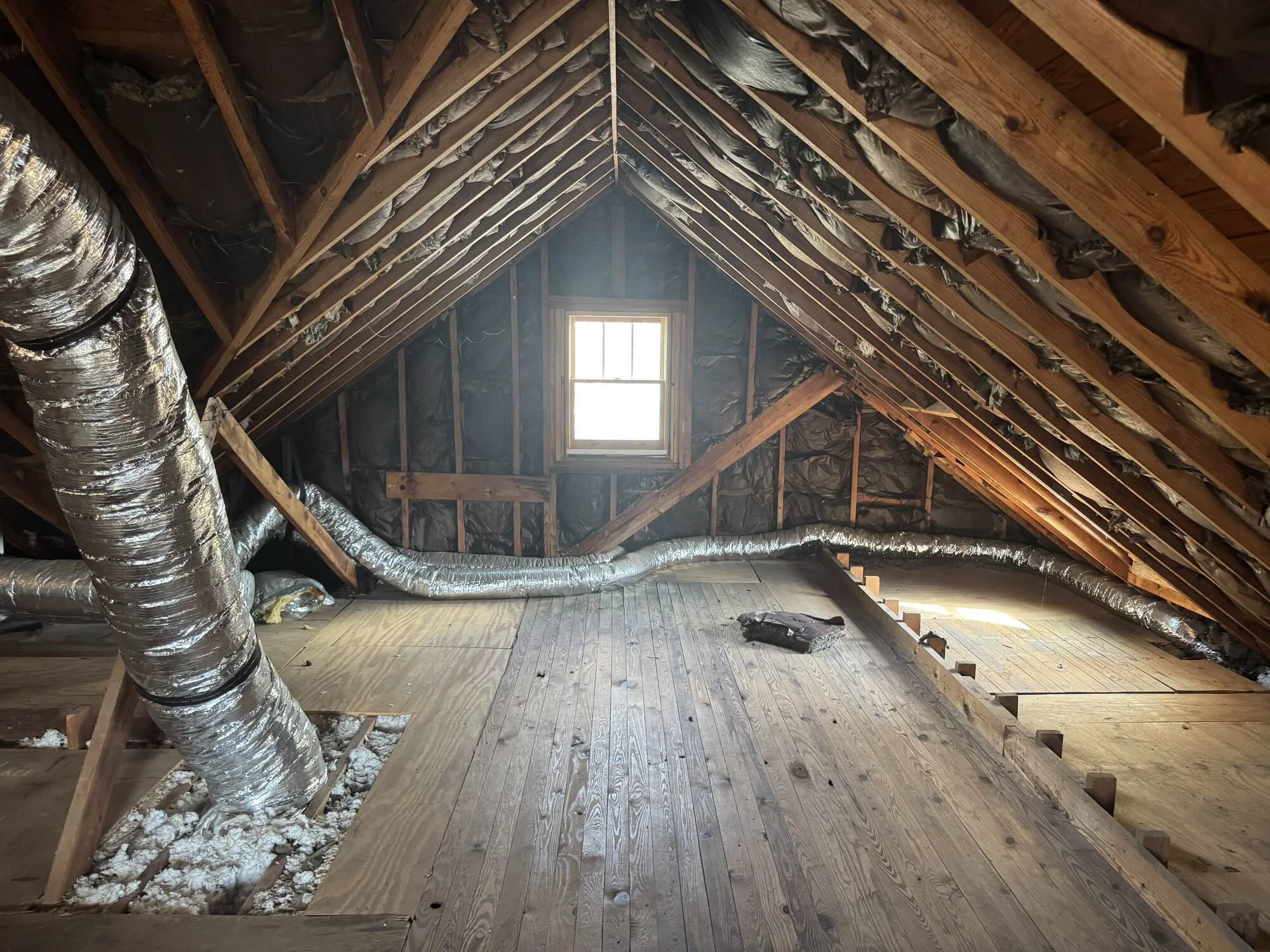 Before — bare attic gable with a single window and open rafters