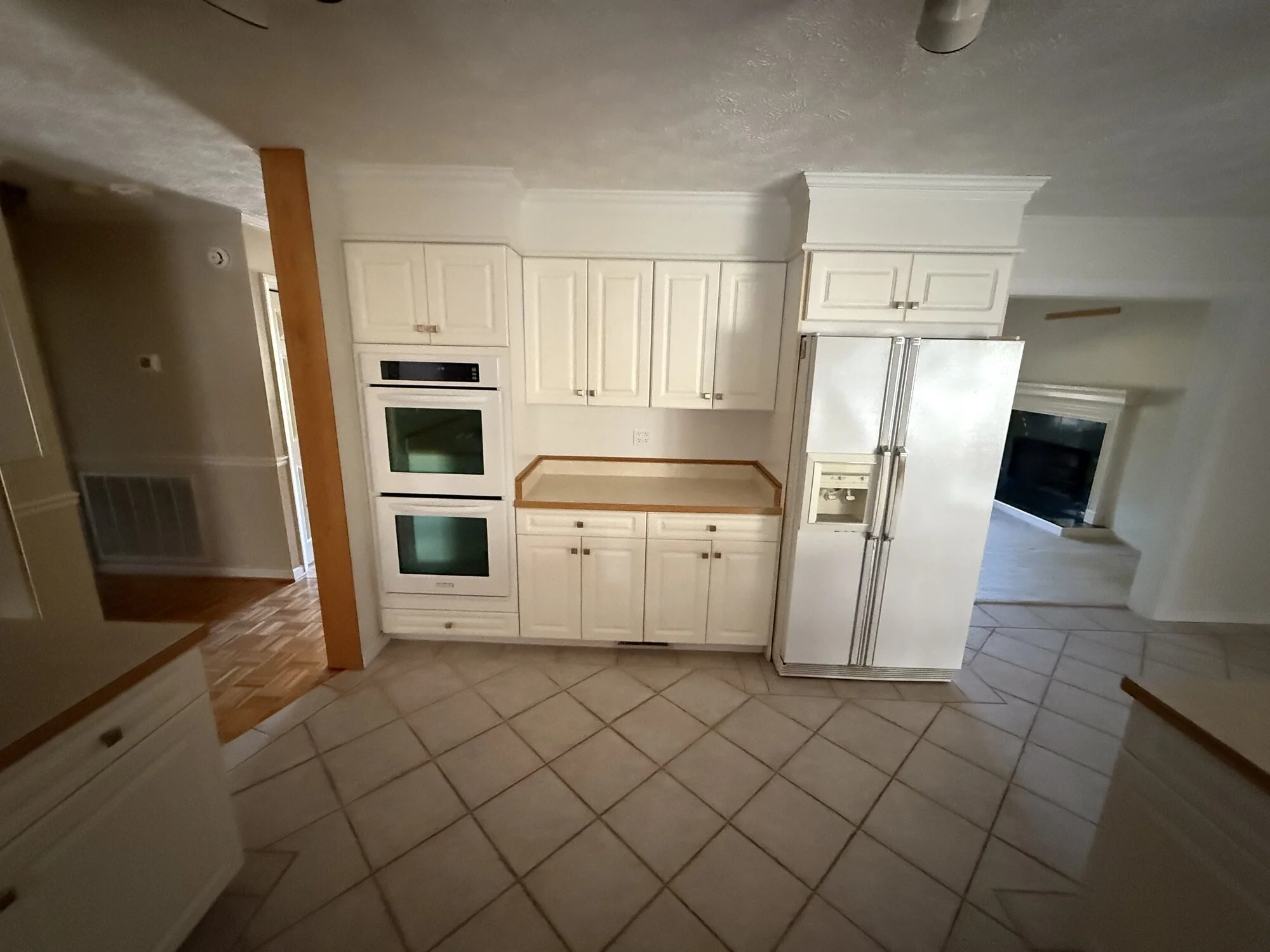 Before — kitchen wall ovens and fridge nook before the rebuild