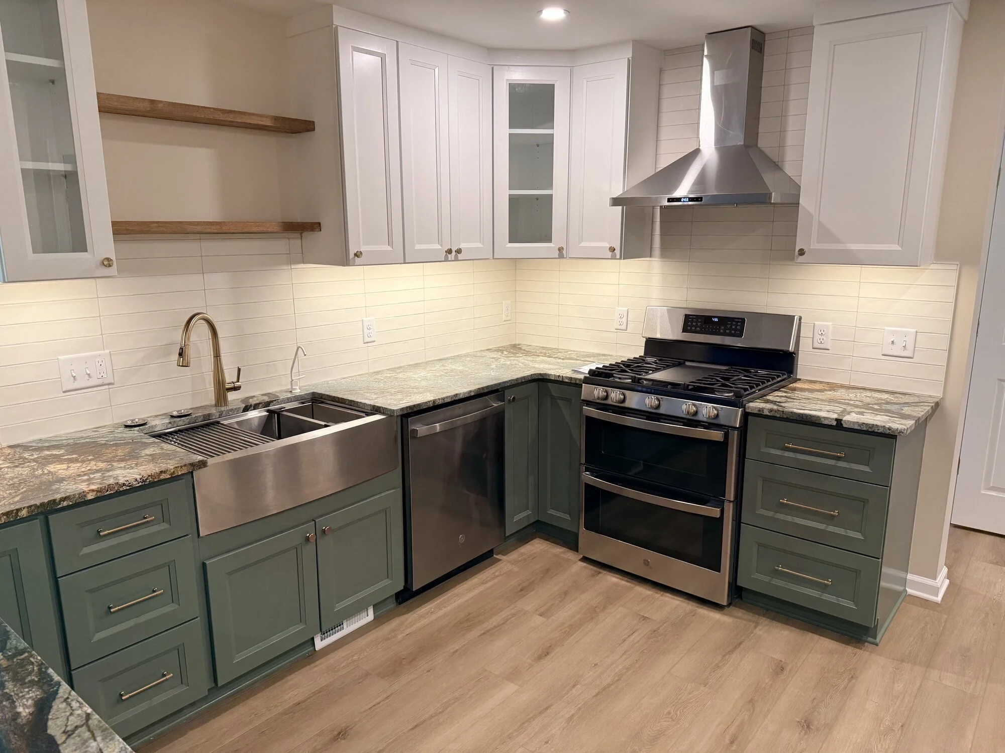 After — range wall with white uppers, stainless hood, and subway tile backsplash