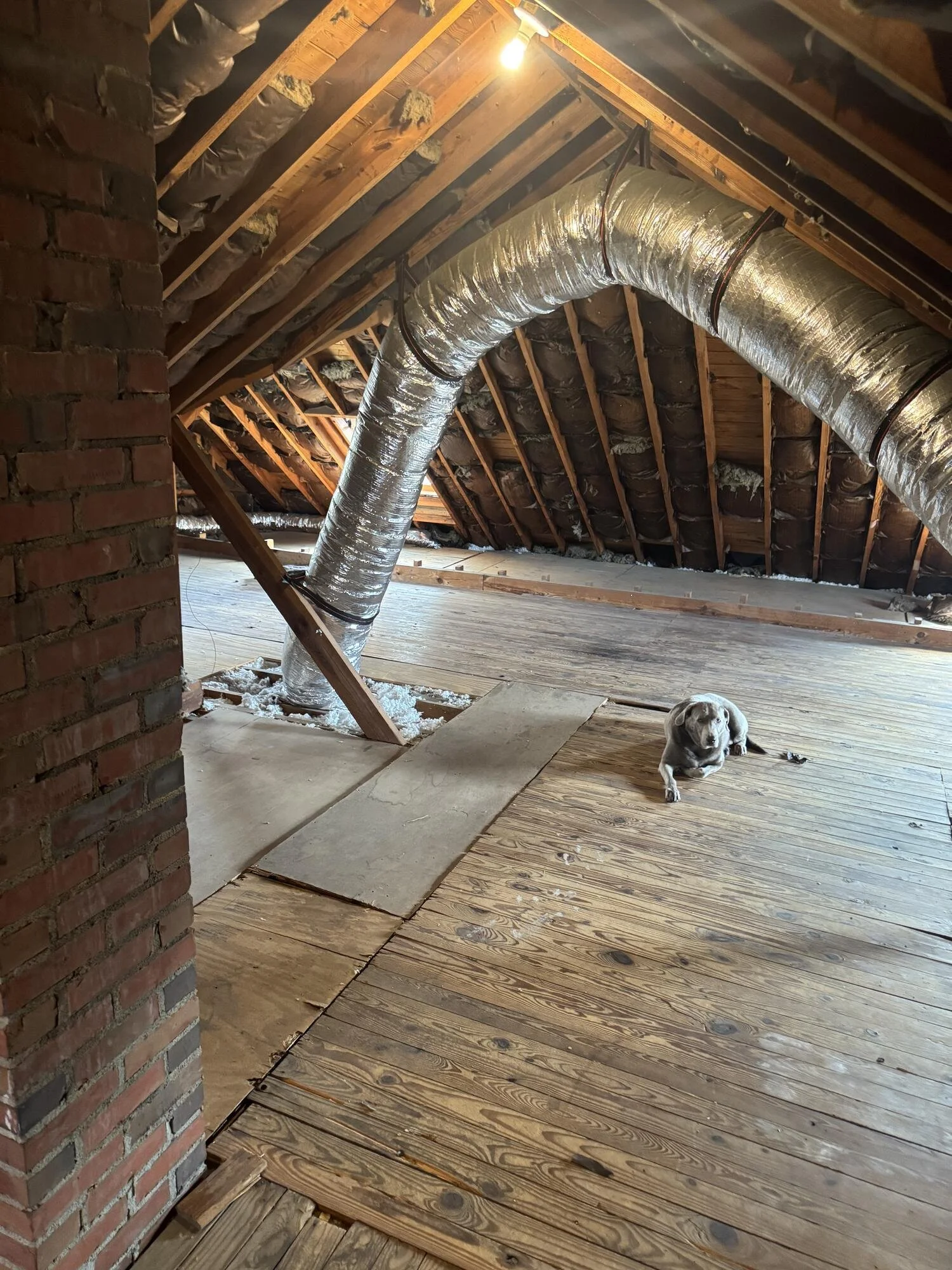 Before — unfinished attic with insulated ductwork snaking across the floor