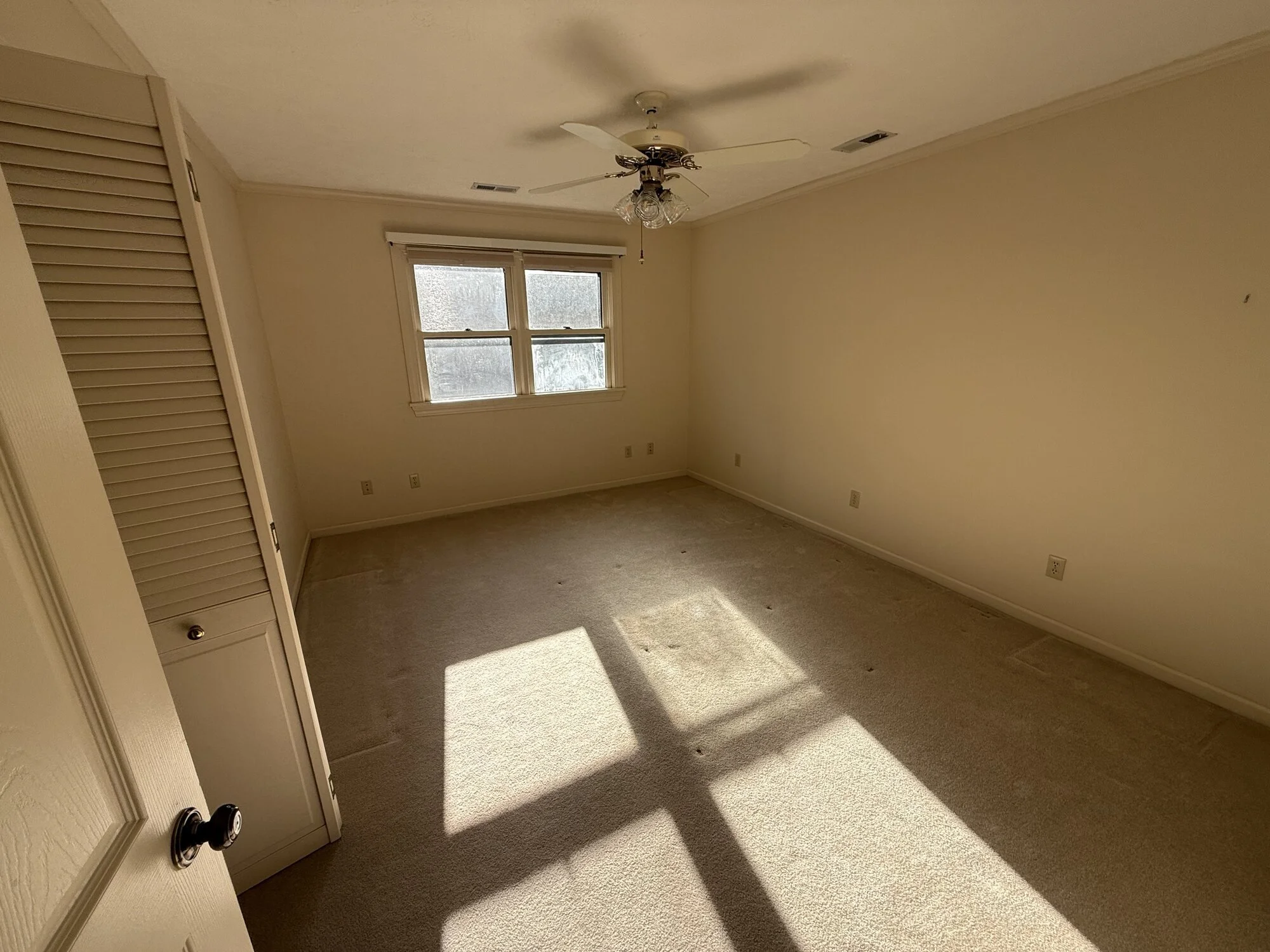 Before — upstairs second bedroom with worn carpet and louvered closet doors