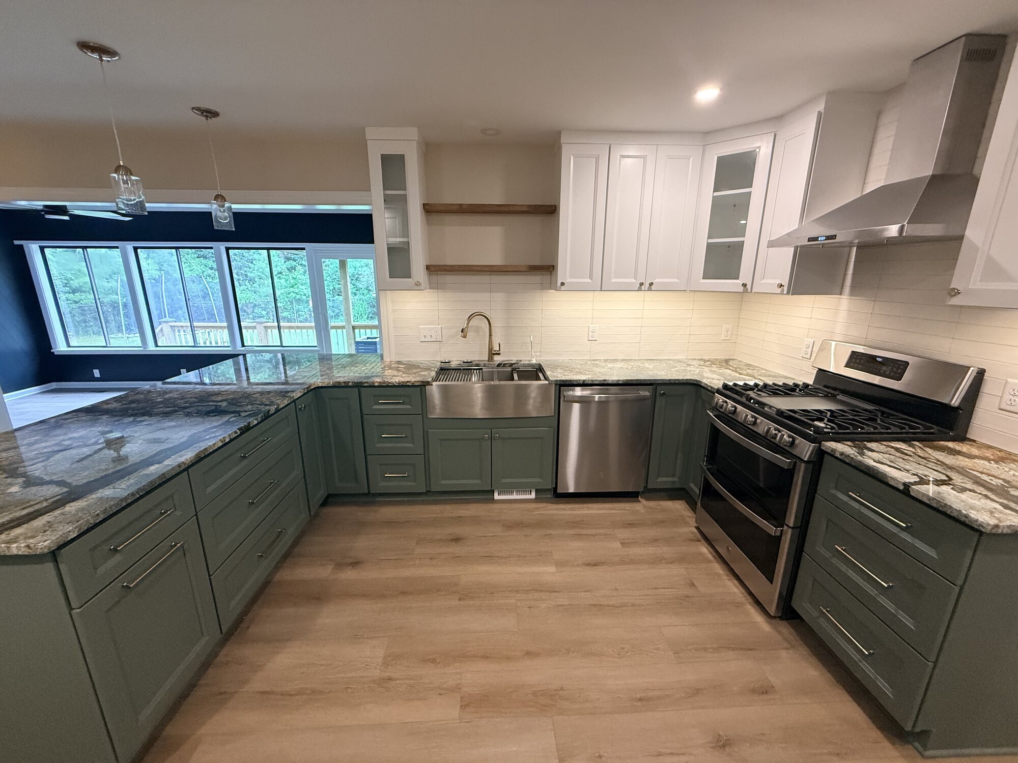 After — the working side: farmhouse sink, dishwasher, and gas range