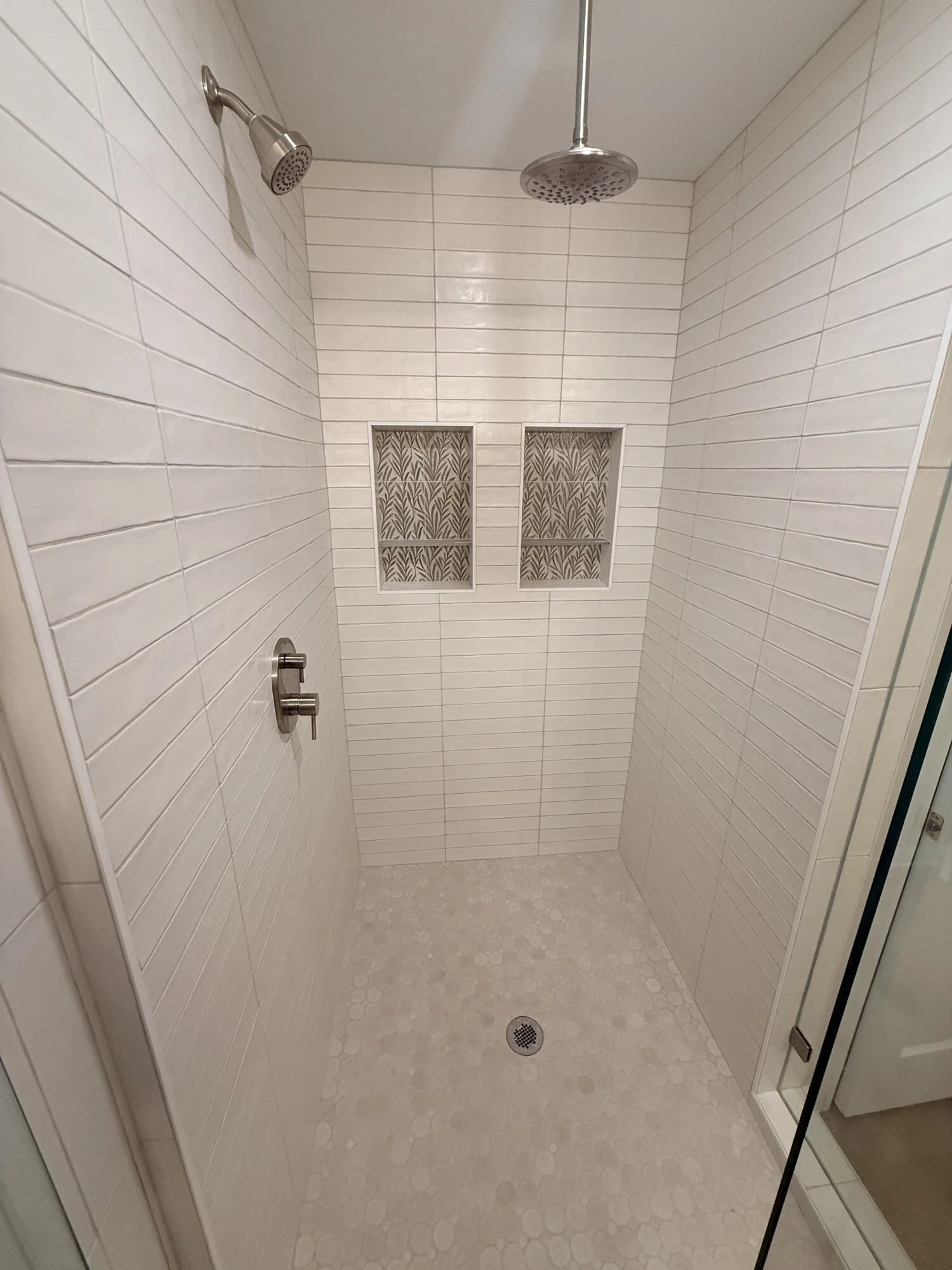 After — shower detail: clean horizontal tile lines and twin decorative niches