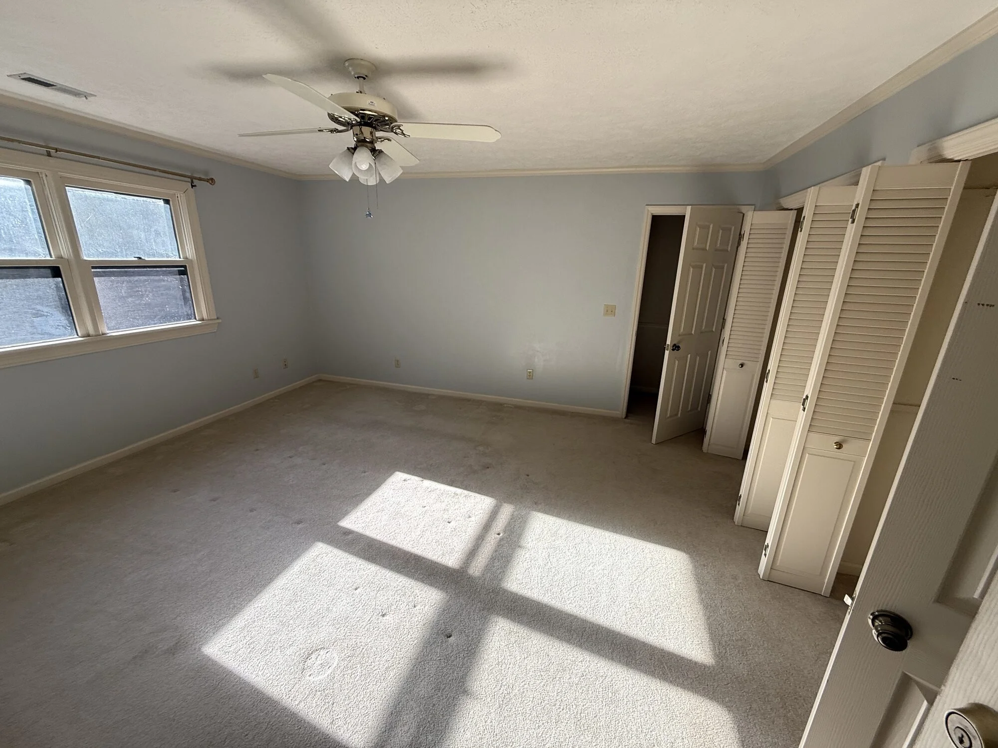 Before — upstairs bedroom with worn carpet and dated closet doors