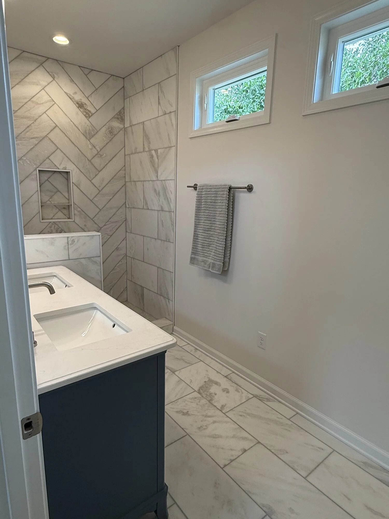 After — walk-in shower with built-in niche and frameless glass