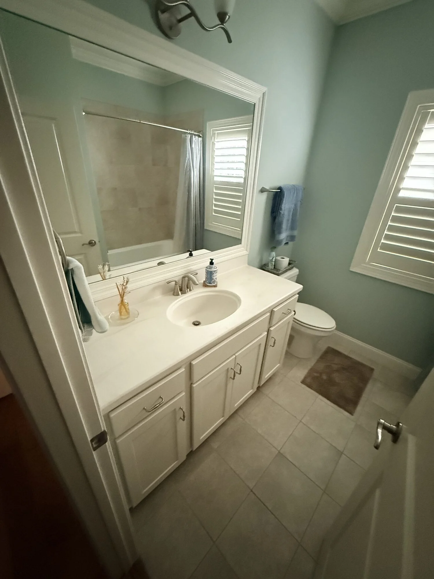 Before — original vanity, countertop, and mirror