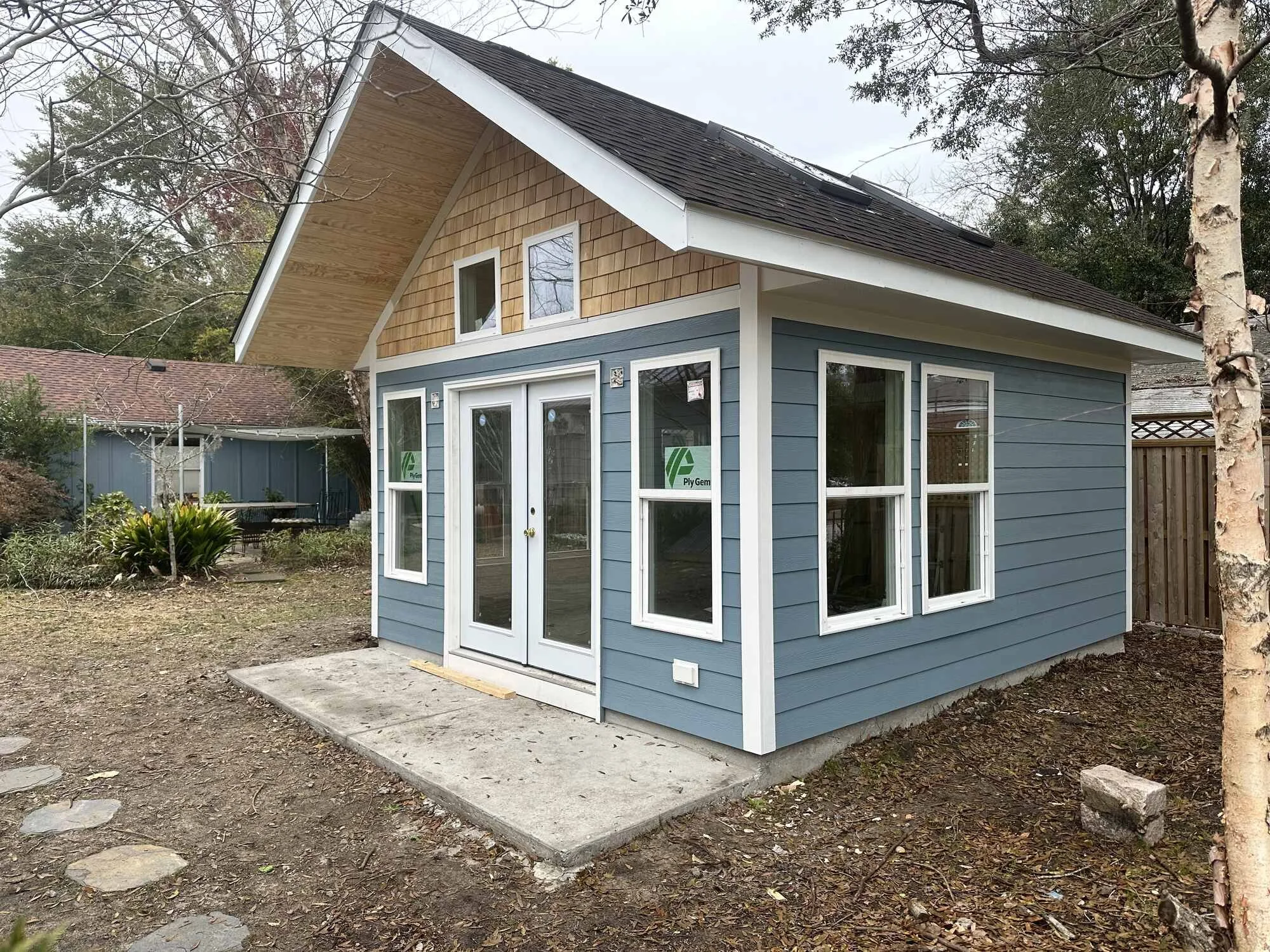 Finished backyard studio with blue lap siding and cedar shake gable — custom outbuilding on Central Blvd, Wilmington NC