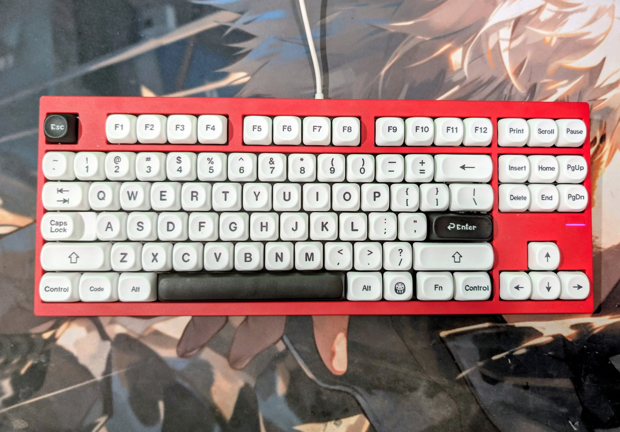 Red with glitter TKL keyboard on a desk mat.