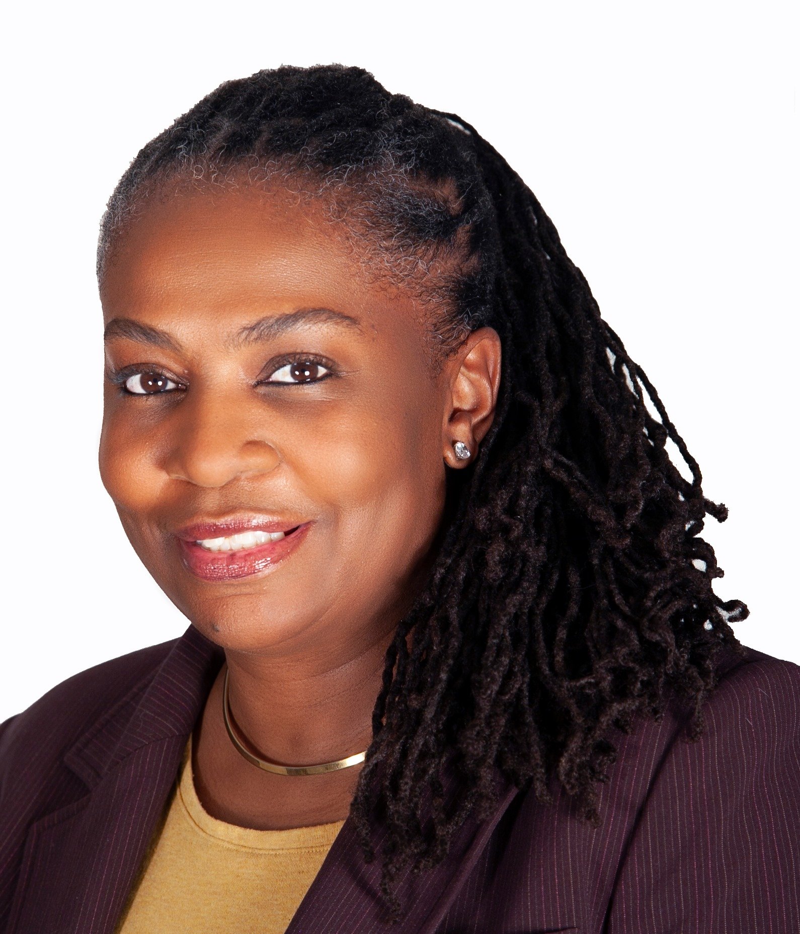 Person smiling into the camera with dark locs pinned back and falling over her shoulder.