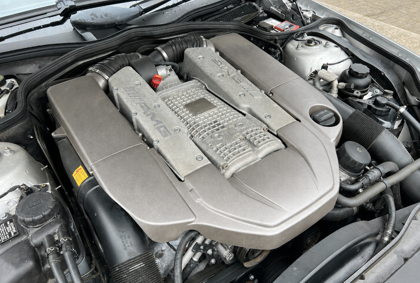 Close-up of a car engine with AMG branding on the engine cover.