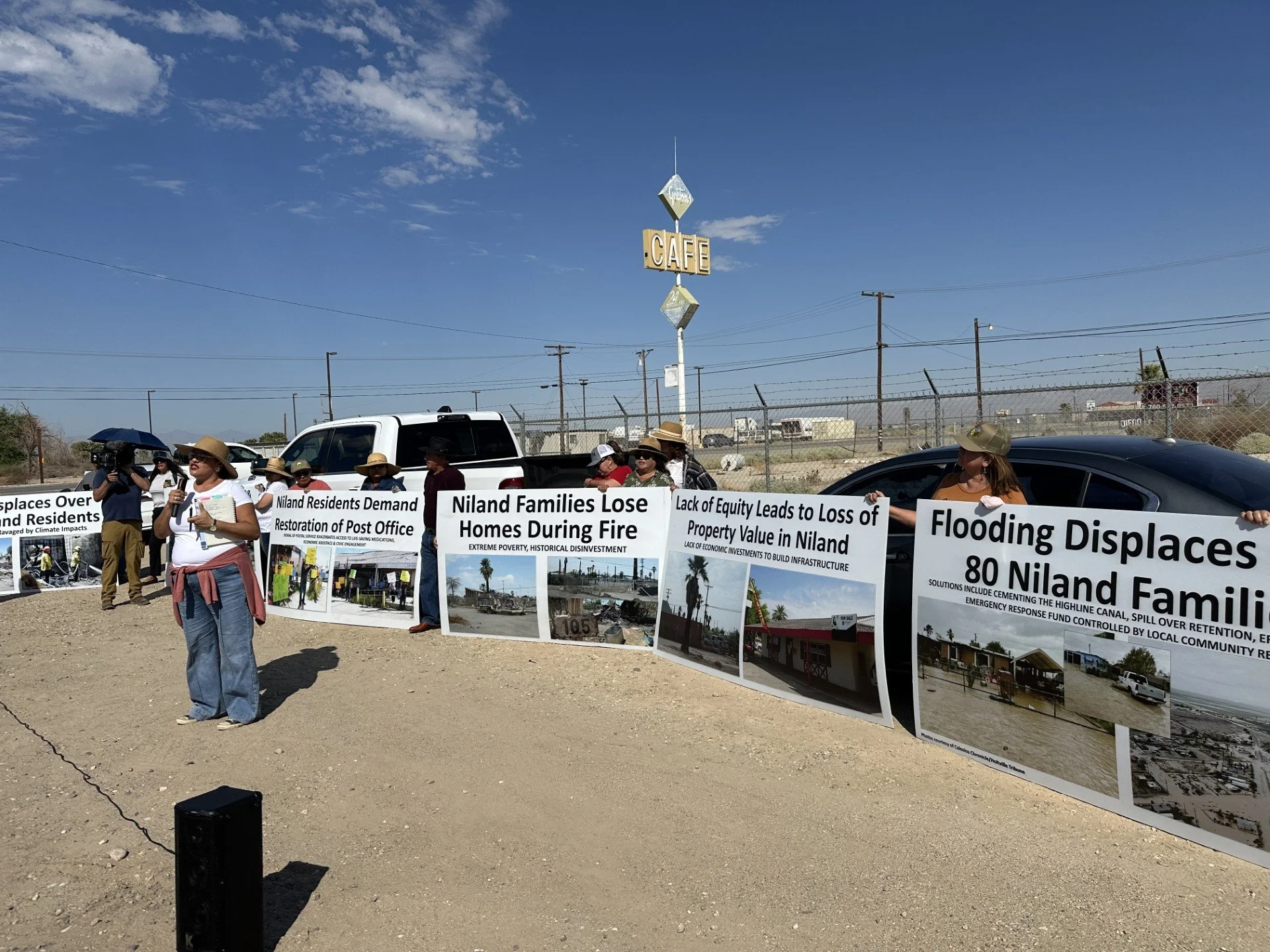 Niland, CA residents protest with large signs and images related to displacement of families and equity concerns