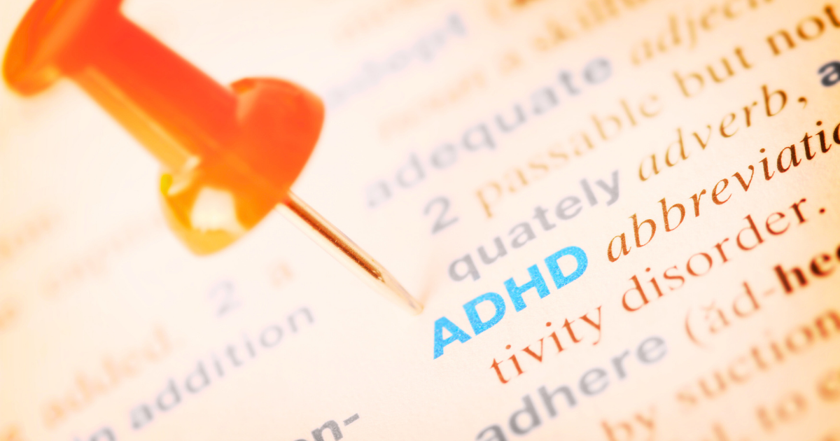 range push pin highlighting the ADHD definition in a dictionary