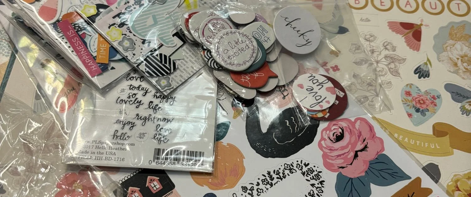 Scrapbooking supplies and decorative paper embellishments spread across a craft table