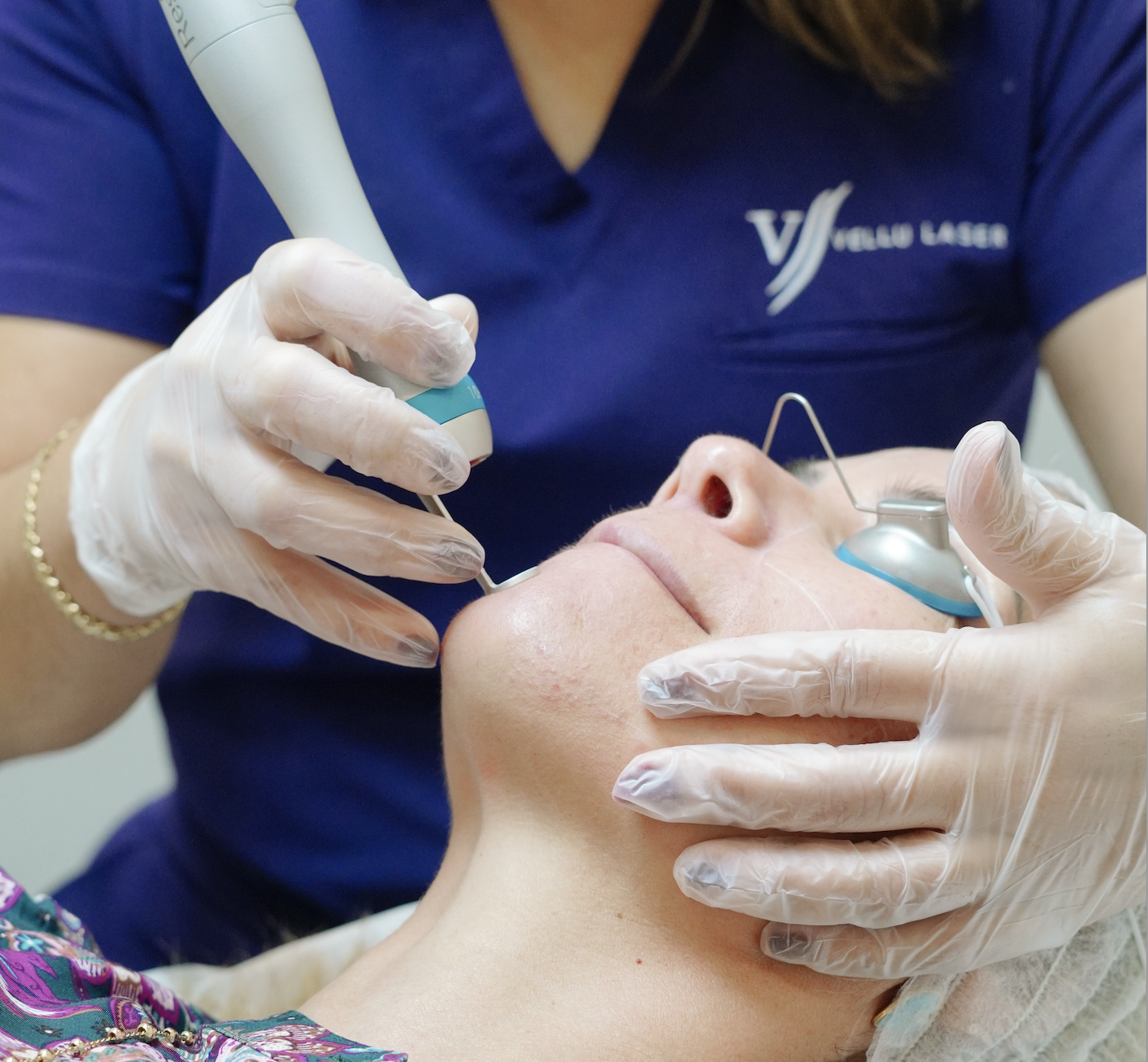 A person receiving a cosmetic facial treatment from an esthetician or dermatologist in a clinical setting.