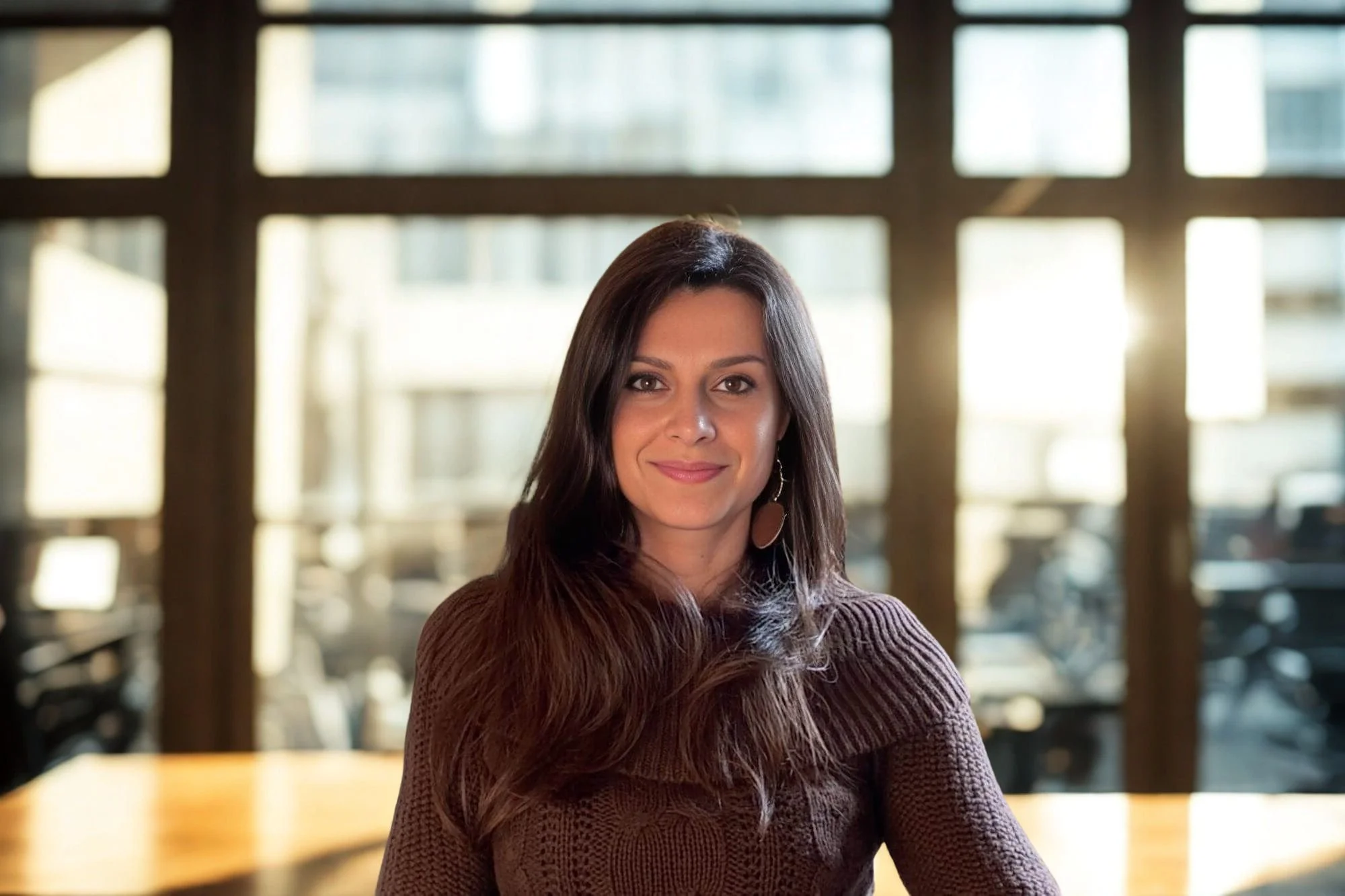 Giulia Davis, LMFT, is sitting in her office. Professional portrait for holistic psychotherapy and online couples therapy in California.