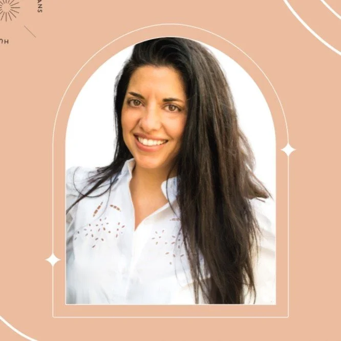 Smiling woman with long dark hair wearing a white blouse in an arched frame on a peach background.