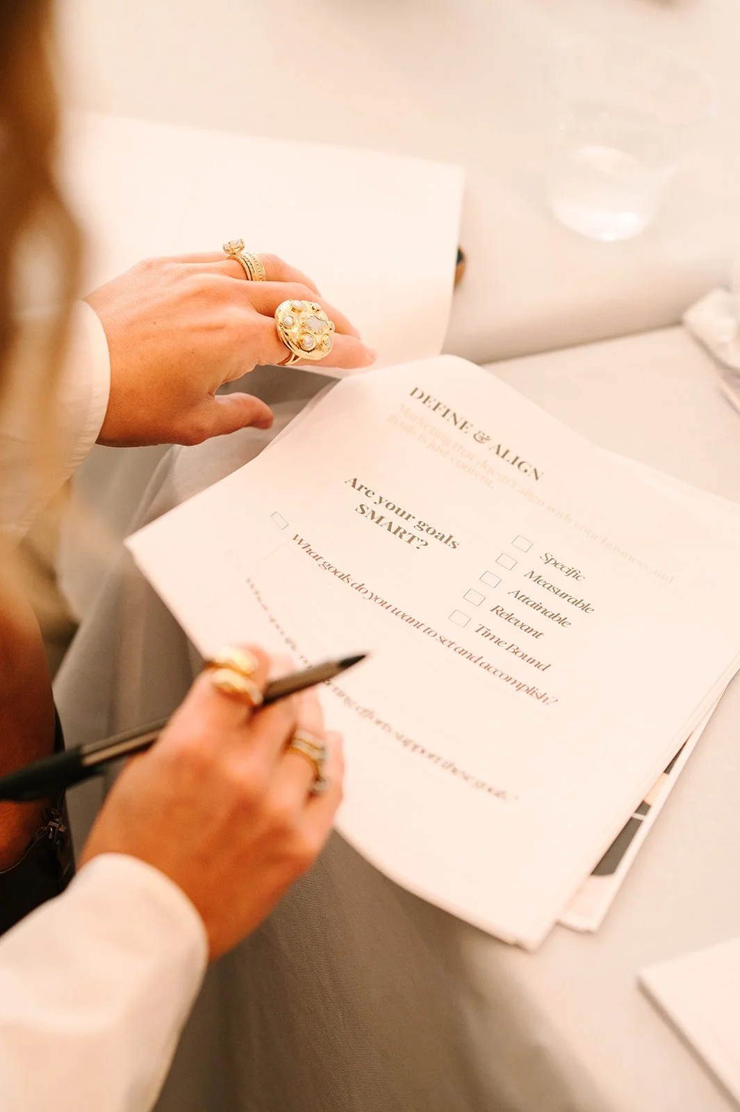 Person reviewing a goals worksheet titled 'Define & Align' with checkboxes for goals, including 'Are your goals SMART?'.