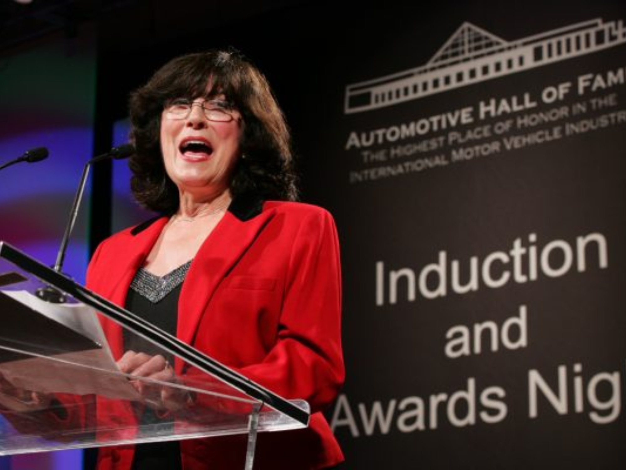 Shirley at a podium accepting the induction into the Automotive Hall of Fame