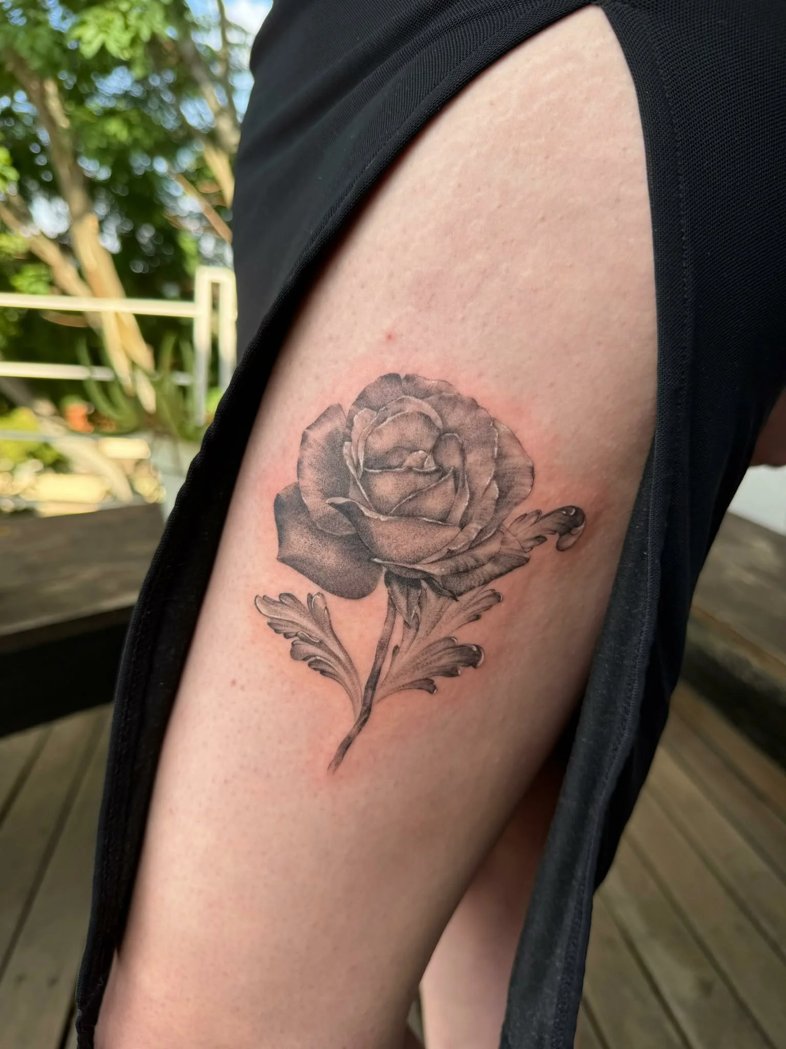 A black and gray tattoo of a rose on a person's upper arm. Realism tattoo, expert tattooing Melbourne