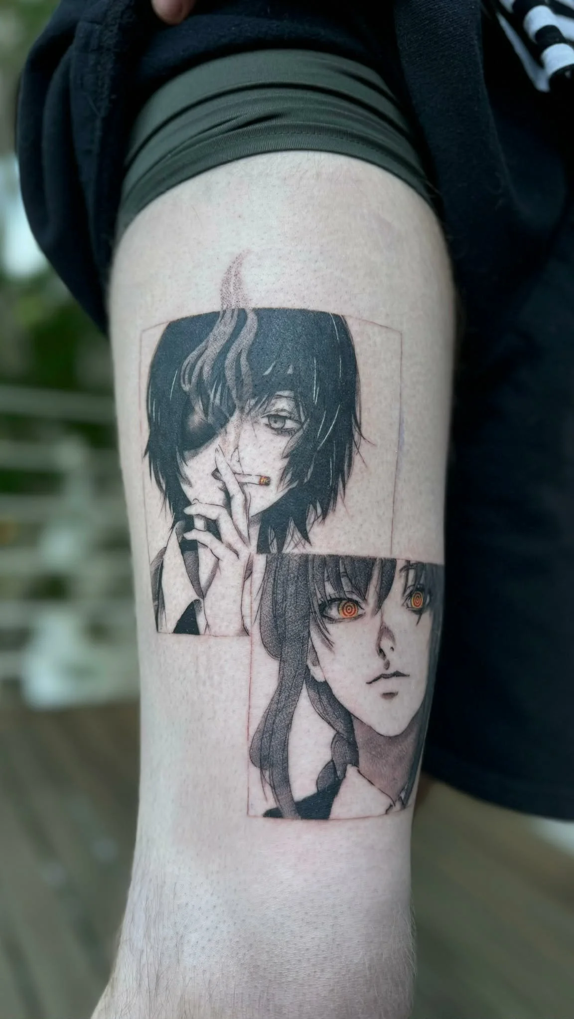 Tattoo on person's upper arm featuring two anime-style characters, one with dark hair covering one eye and smoking, the other with long hair and glowing eyes.heart and home tattoo. best tattoos Melbourne