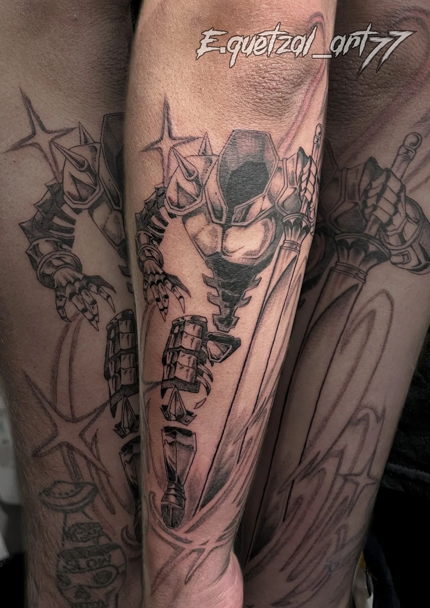 Black and gray tattoo of a robotic, dragon-like creature with sharp claws and an armored body on a person's arm.