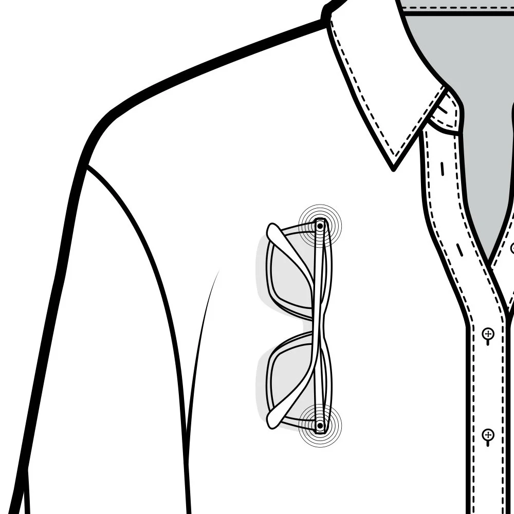 Close-up of a shirt and eyeglasses hanging on a shirt pocket, with the shirt edgestitched and a collar visible.