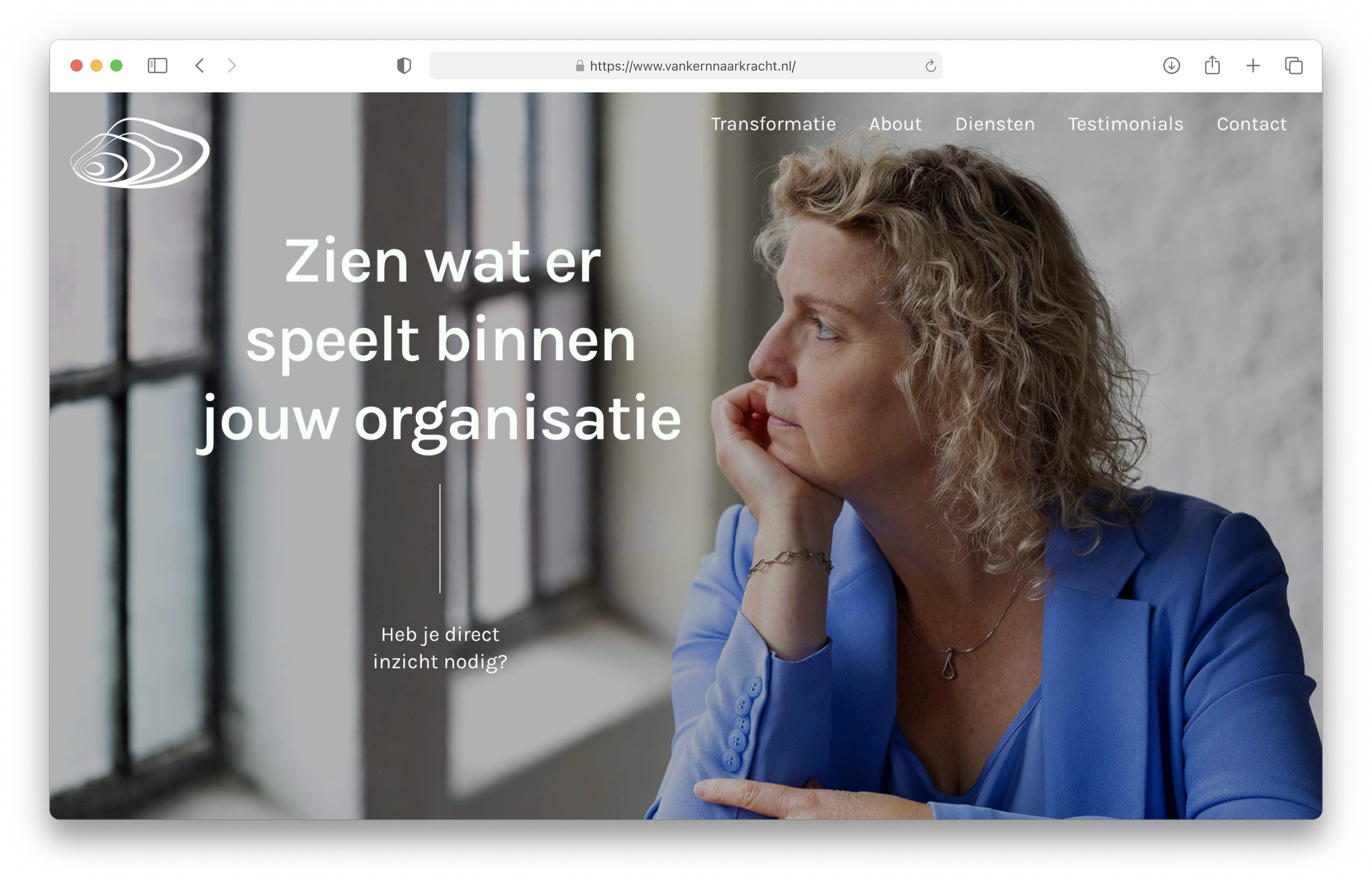 A woman in a blue blazer sitting near a large window, looking thoughtfully outside with her hand resting on her chin, on a website homepage about organization transformation.