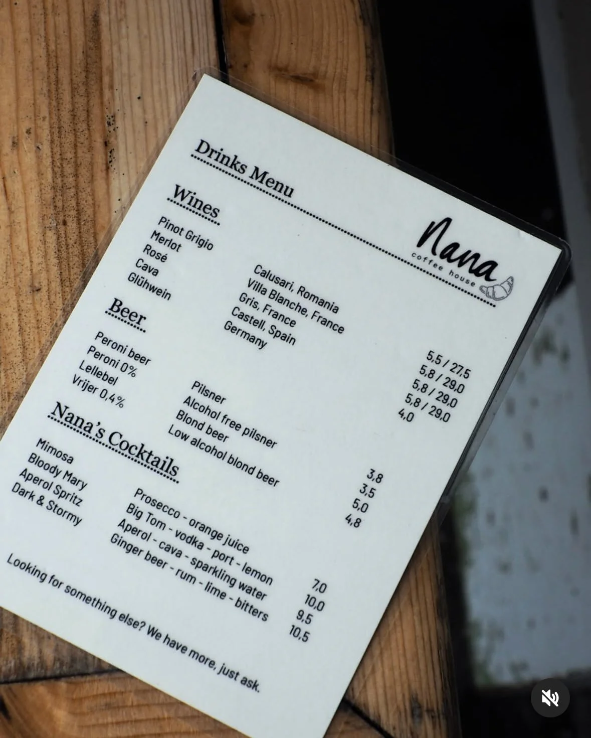 Coffee shop drinks menu with sections for wines, beer, and cocktails, listing different varieties and prices.