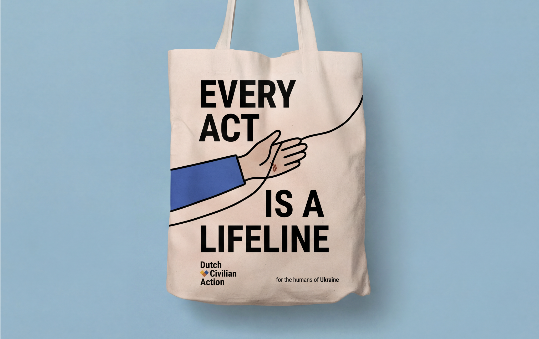 A beige tote bag with a design showing a hand pulling a thread, with the text 'Every act is a lifeline'. The bag also has a logo for Dutch Civilian Action and a note 'for the humans of Ukraine'.