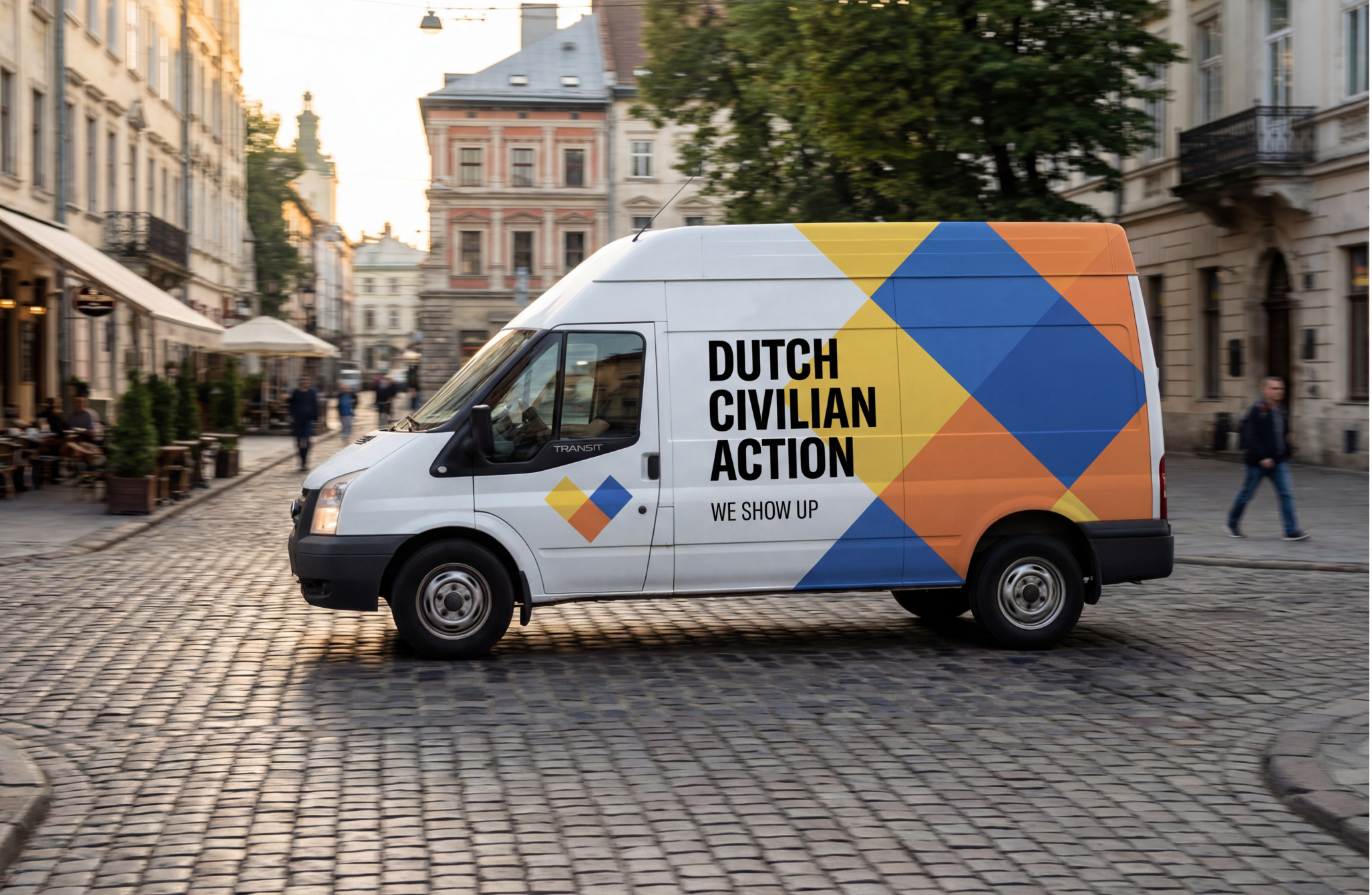 A white van with colorful geometric designs and the words 'Dutch Civilian Action - We Show Up' printed on the side, driving on a cobblestone street in an urban area with buildings and pedestrians.