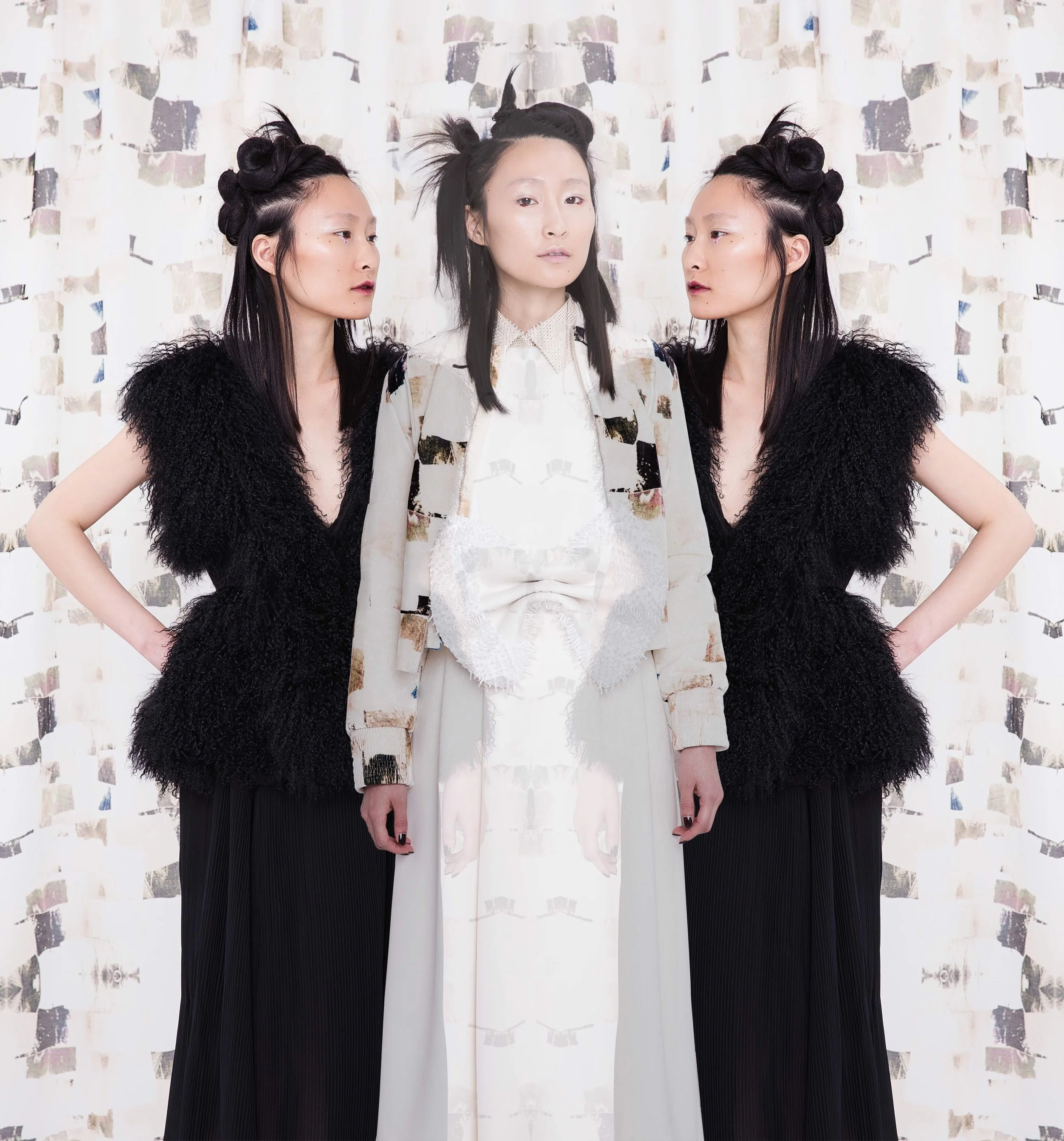 Three women standing in front of a patterned backdrop, with the middle woman appearing as a mirrored, ghostly duplicate of herself.