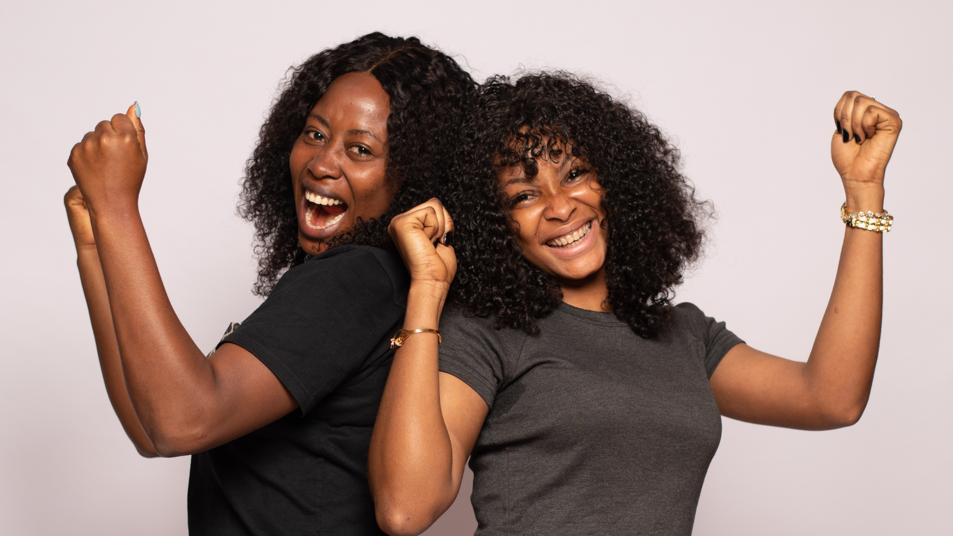Two black women smiling and celebrating together