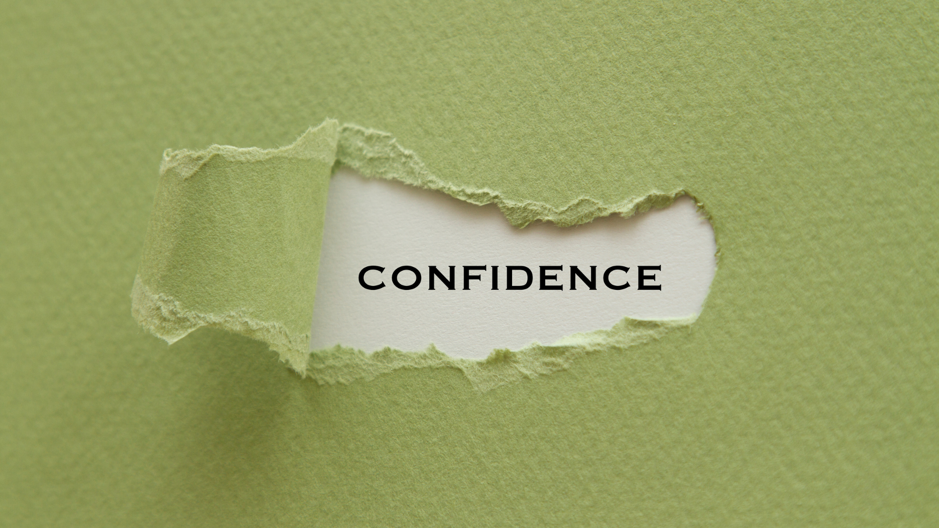 Torn green paper revealing the word “Confidence” underneath.