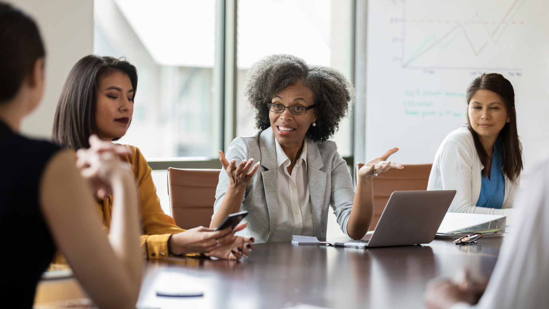 Diverse women in boardroom conversation
