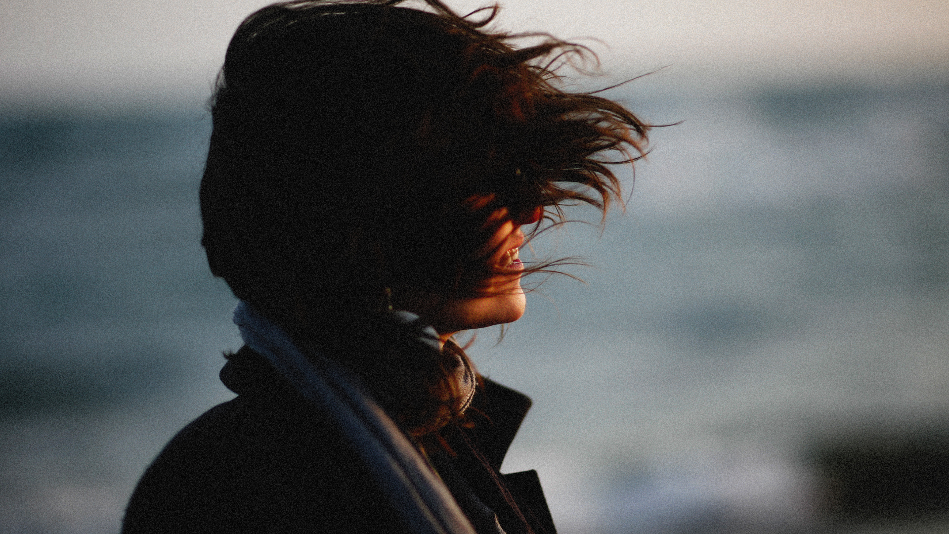 A woman standing outdoors in the wind