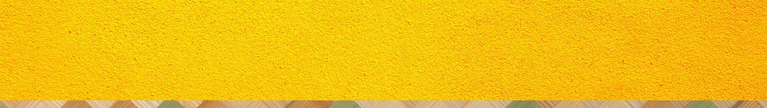 Close-up image of a yellow textured surface with a wooden border at the bottom.