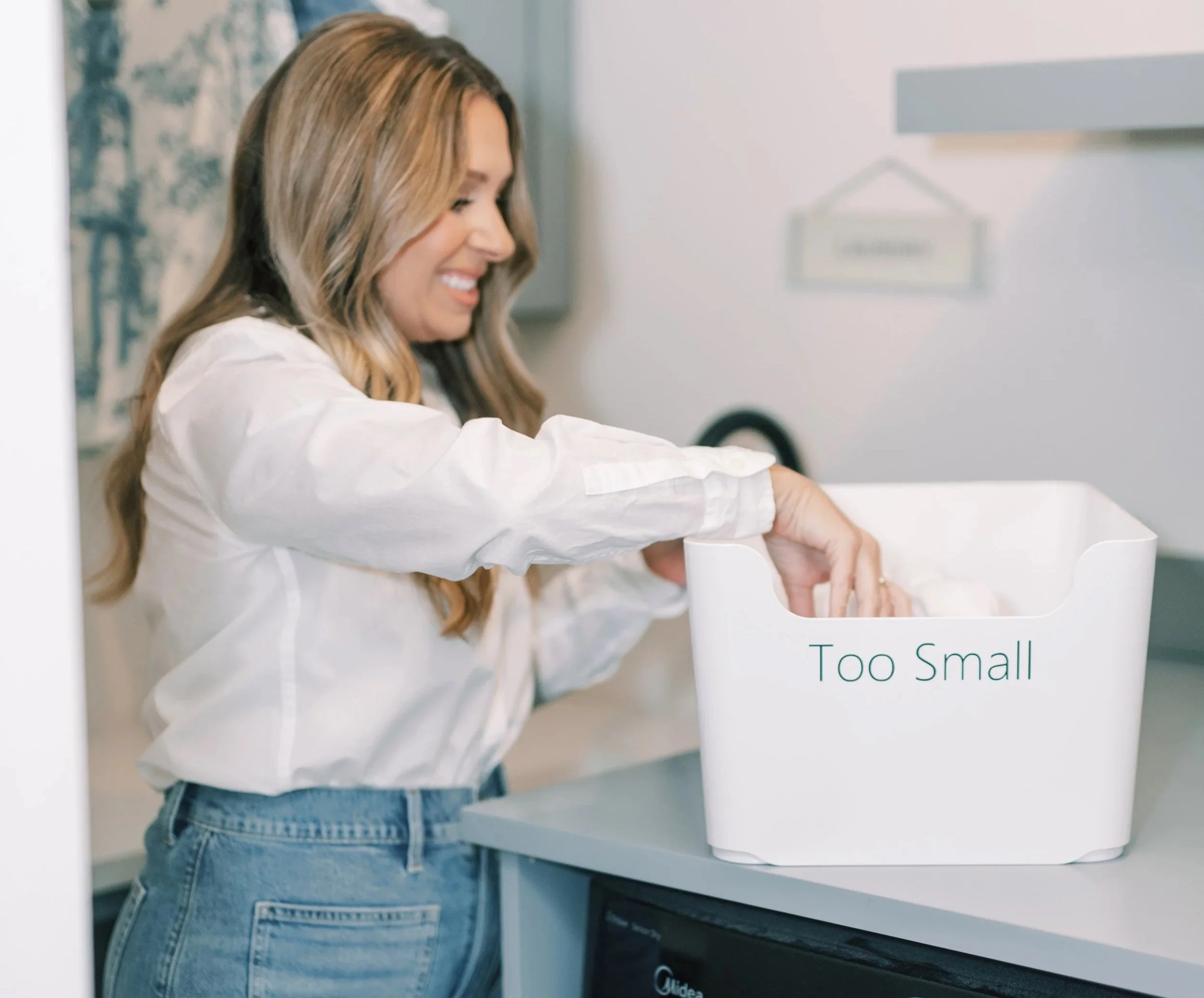 Professional organizer sorting items into a labeled donation bin during a home decluttering and organization project.