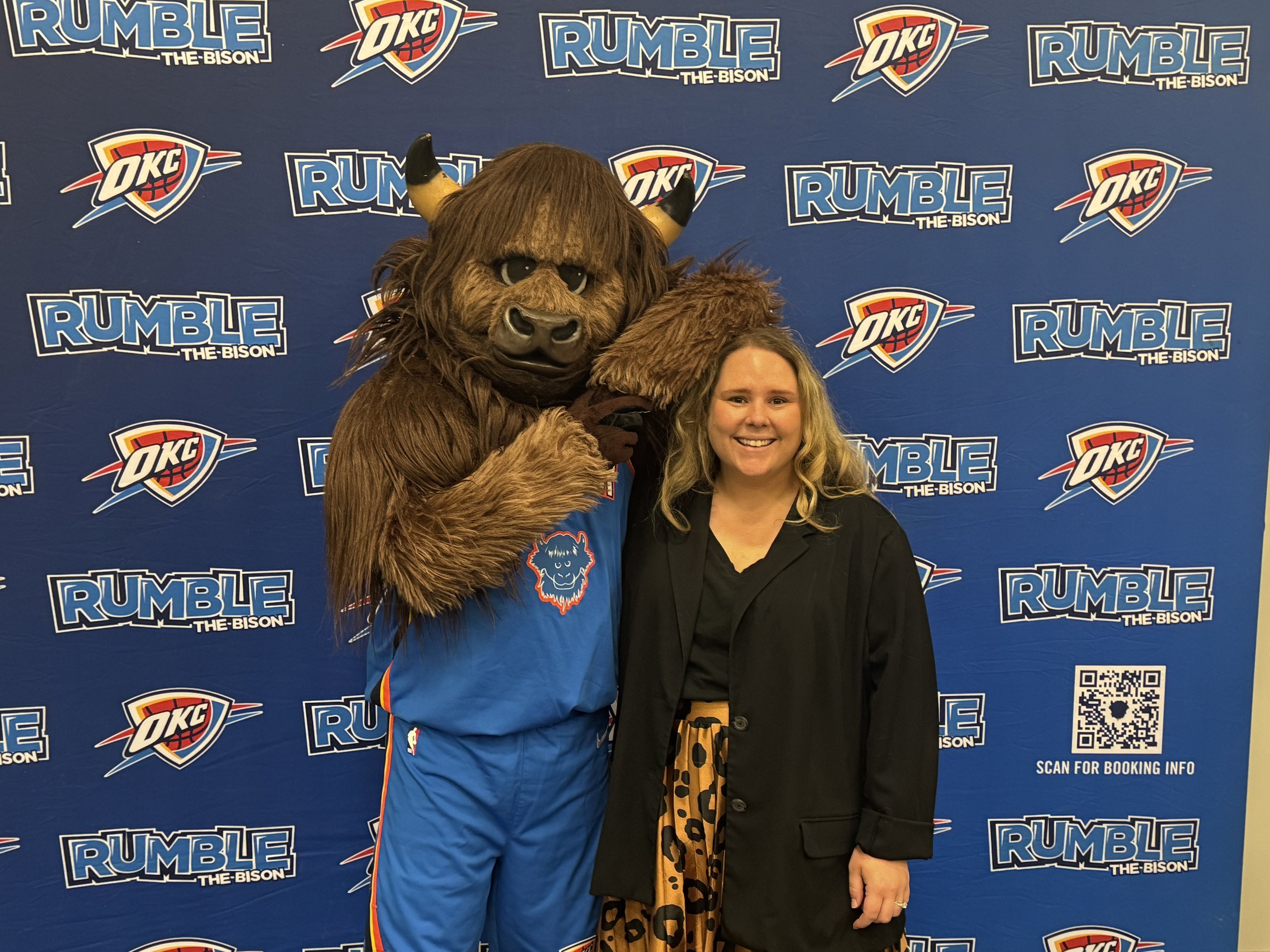 Thunder mascot on the left posing with subject in business casual on the right.