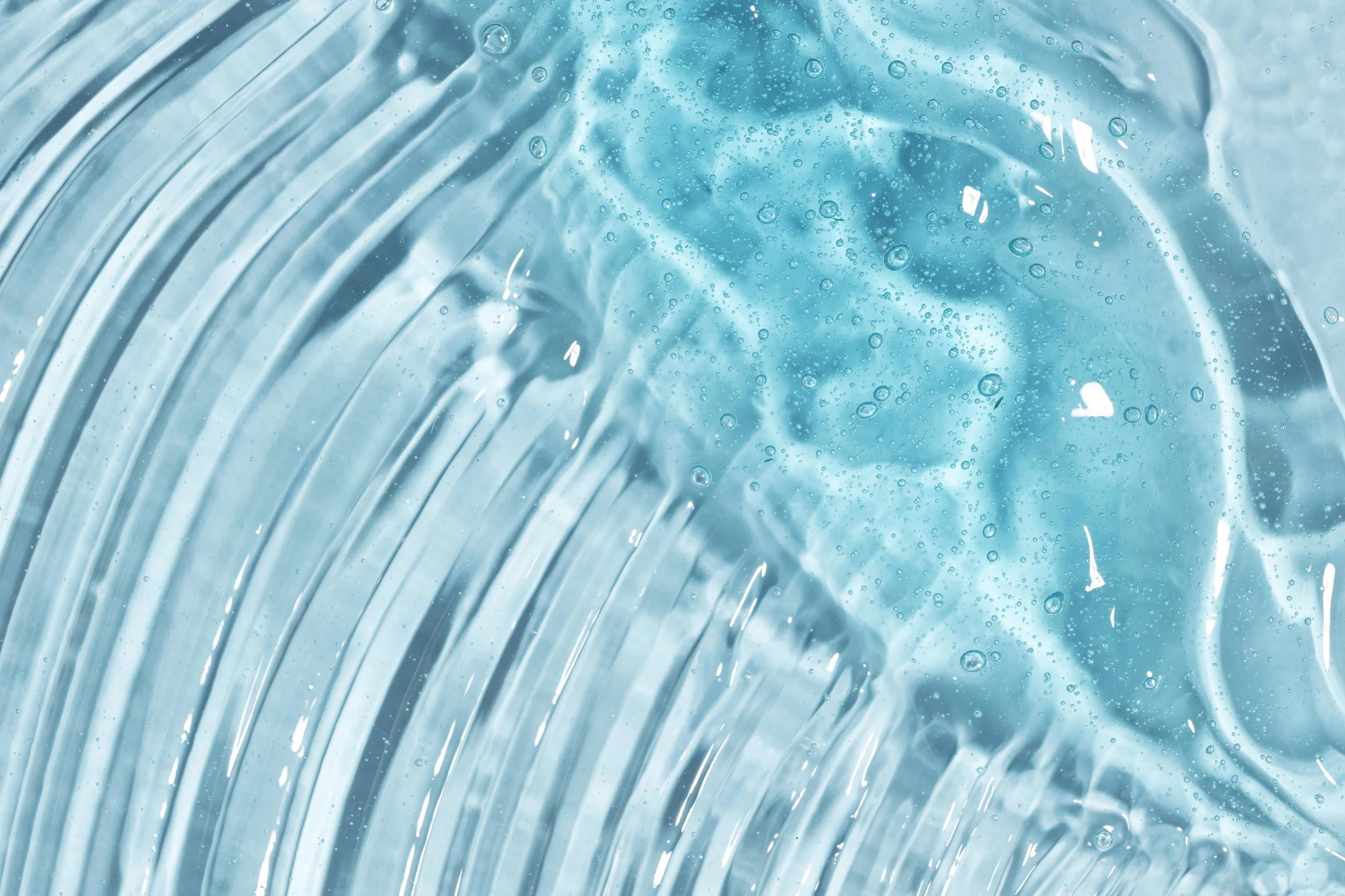 Close-up of swirling water with bubbles and streaks.